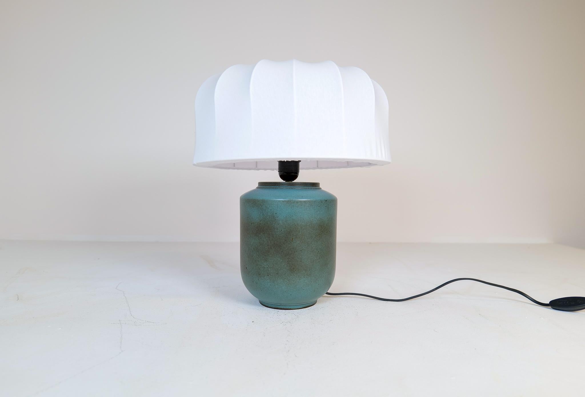 Elegant ceramic table lamp by Gunnar Nylund for Rörstrand, Sweden. The colors of the glaze have a very shifting and elegant look. This ceramic lamp piece is a rare one to find. The shade is a new mushroom shade made in Sweden. 

Good working
