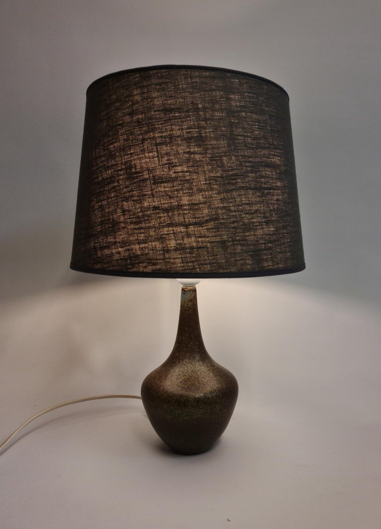 Wonderful small ceramic table lamp by Gunnar Nylund for Rörstrand, Sweden. The harfur glaze as with many of Nylunds objects from this time works perfectly with the form of the lamp. 

Good working condition. New Shade.

Dimension: With shade H