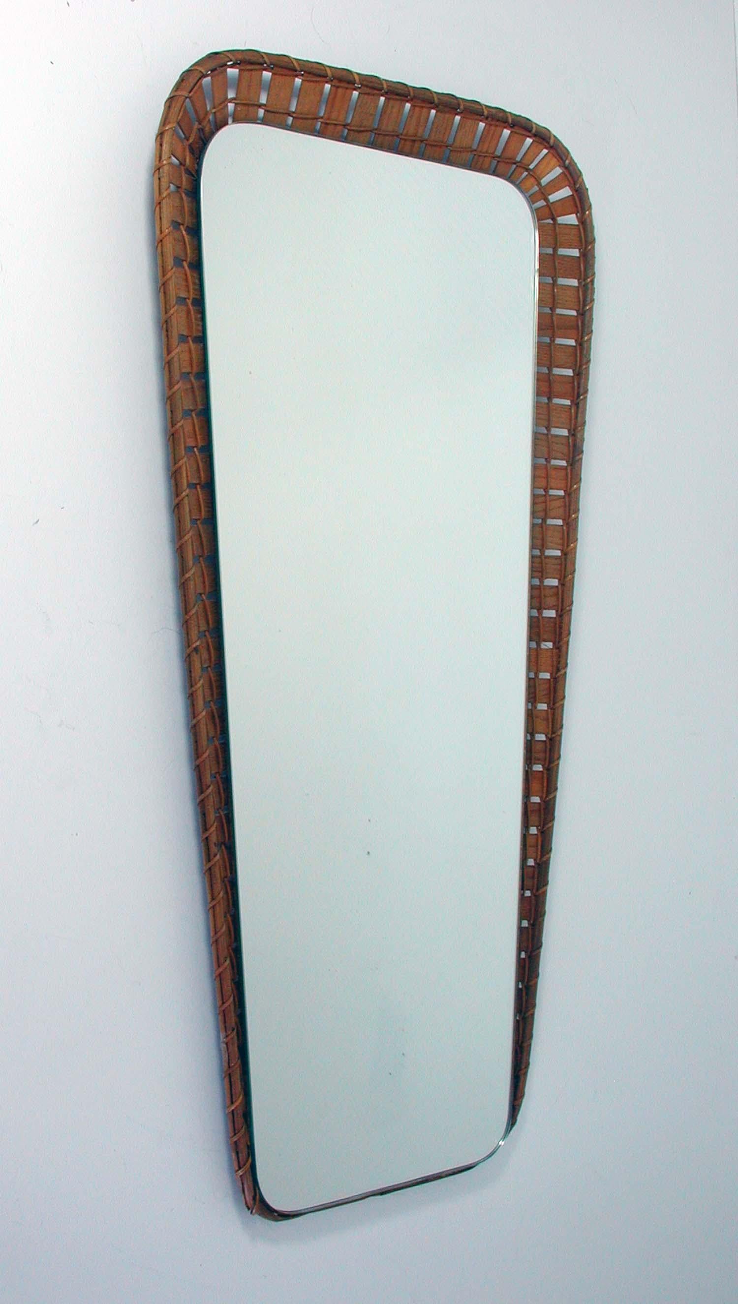 This elegant wall mirror was designed and manufactured in Sweden in the 1950s. It has got a conical rattan frame and is in very good condition with only minor signs of use.