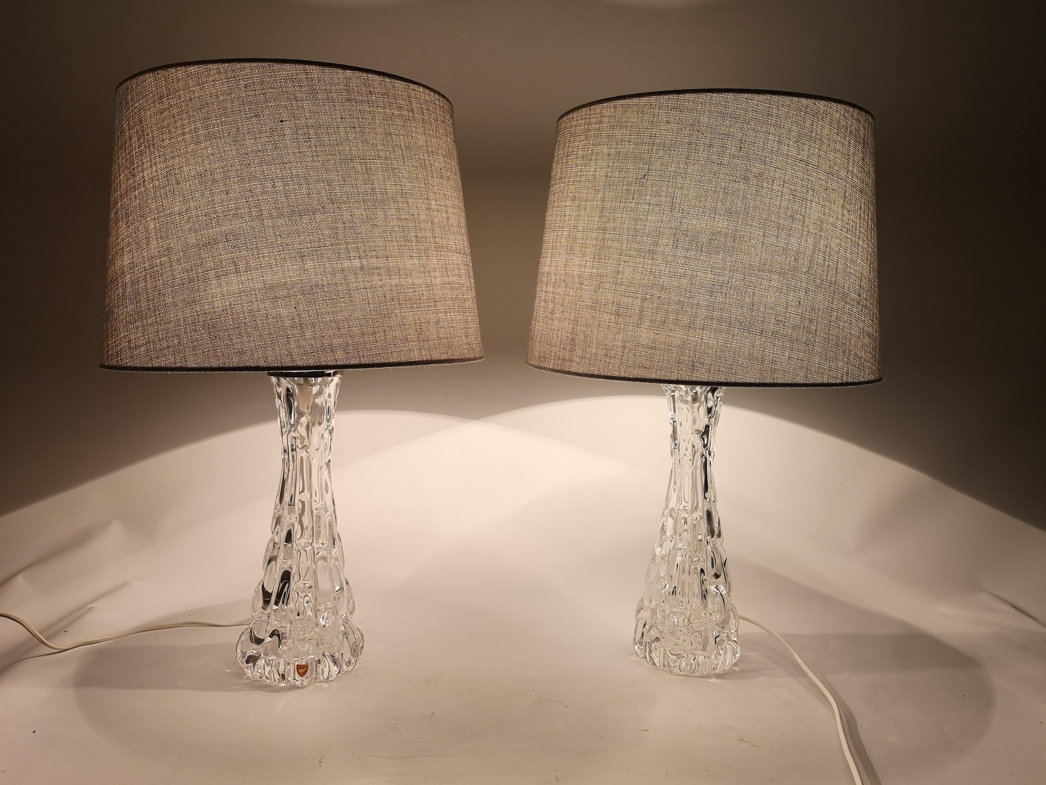 Exceptional pair of heavy hourglass form crystal lamps with polished nickel fittings. The lamps were made in Sweden at Orrefors glasbruk.
The designer Carl Fagerlund has created at glass that perfectly combines art and function. 

They are sold