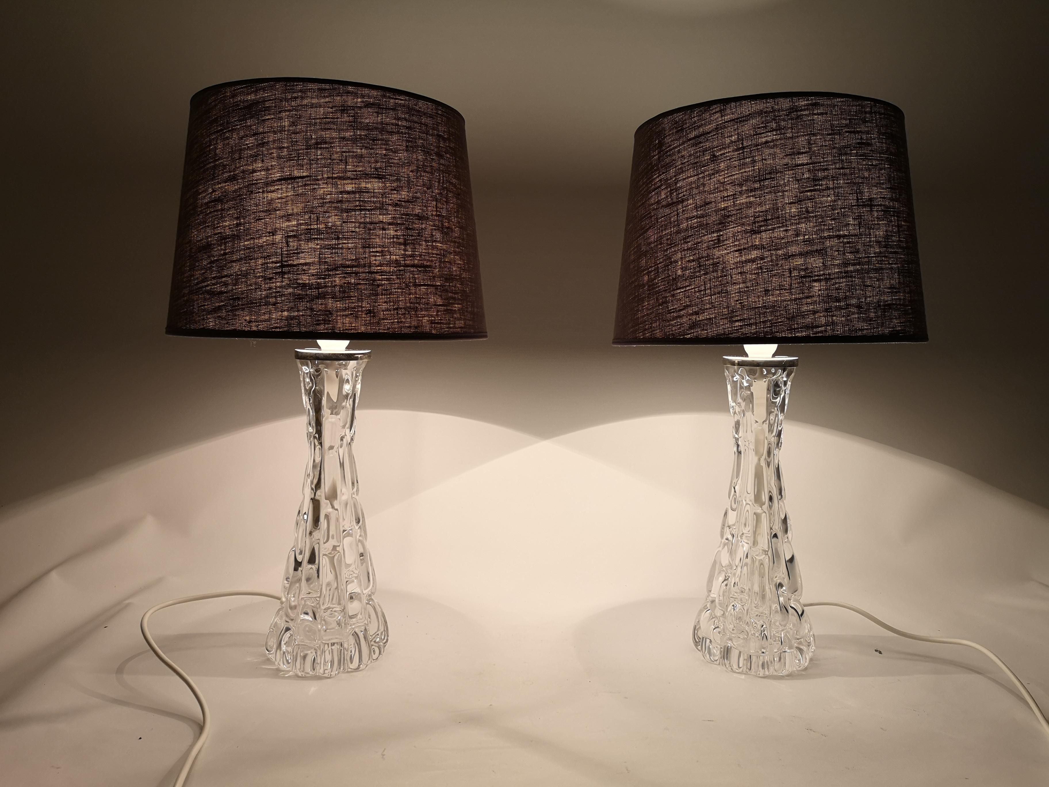 Exceptional pair of heavy hourglass form crystal lamps with polished nickel fittings. The lamps were made in Sweden at Orrefors glasbruk.
The designer Carl Fagerlund has created at glass that perfectly combines art and function. 

They are sold