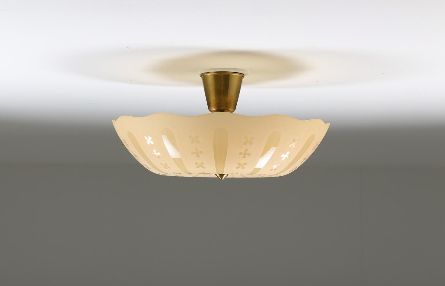 Beautiful flush mount in glass and brass. 
The lamps consist of three light sources, hidden by a yellow-brown glass shade.

Condition: Very good, some minimal dents on the inside of the shade's edge.
   