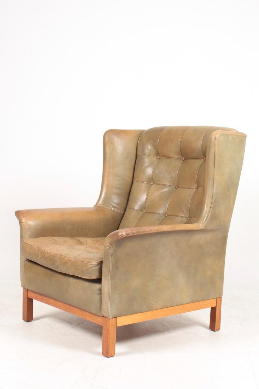 Lounge chair in patinated leather designed by Arne Norell and made by Norell Möbel AB in Sweden.
