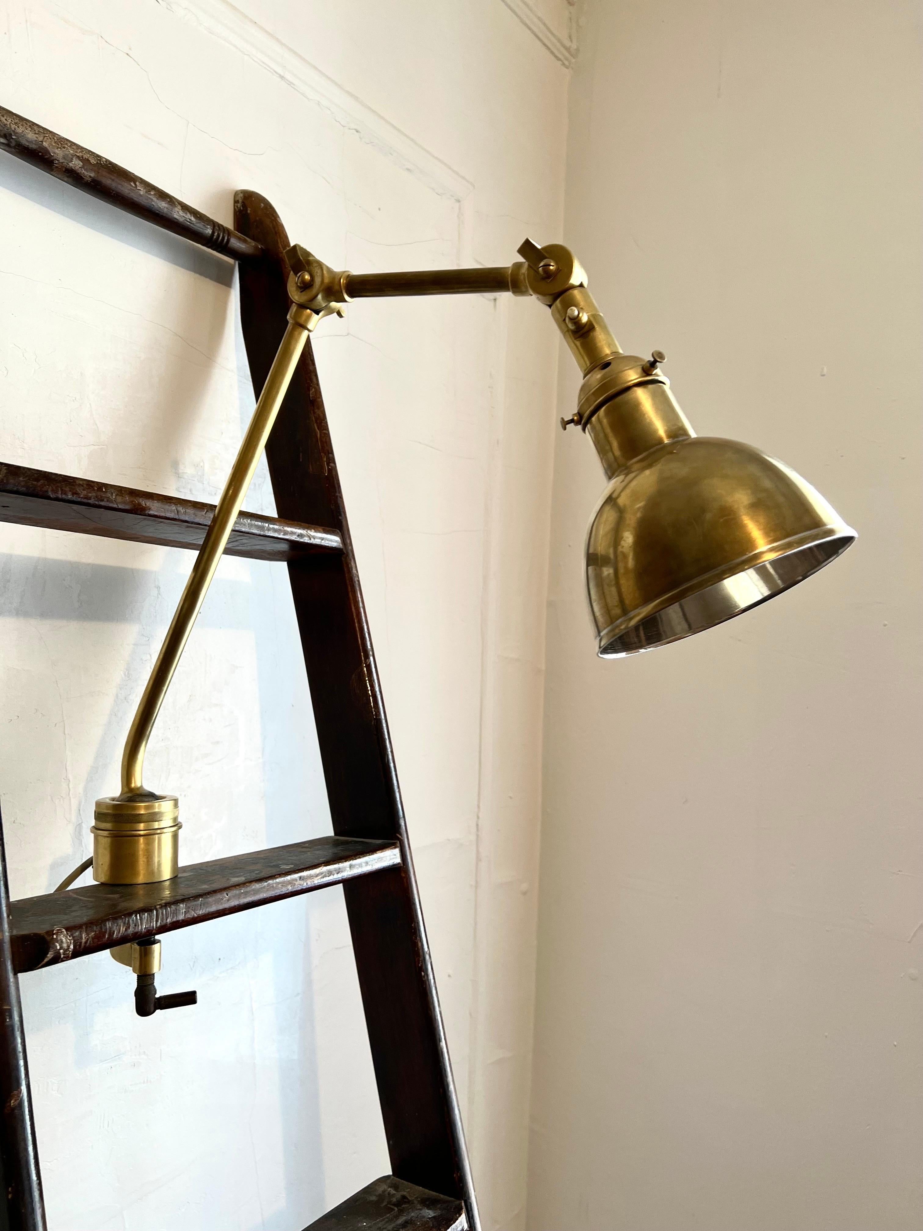 Swedish Mid-Century Modern Marine Industrial clamp lamp in solid brass with a vintage hand made ladder forming a floor lamp. The Swedish clamp lamp and ladder were salvaged from a Swedish luxury vessel circa 1950.