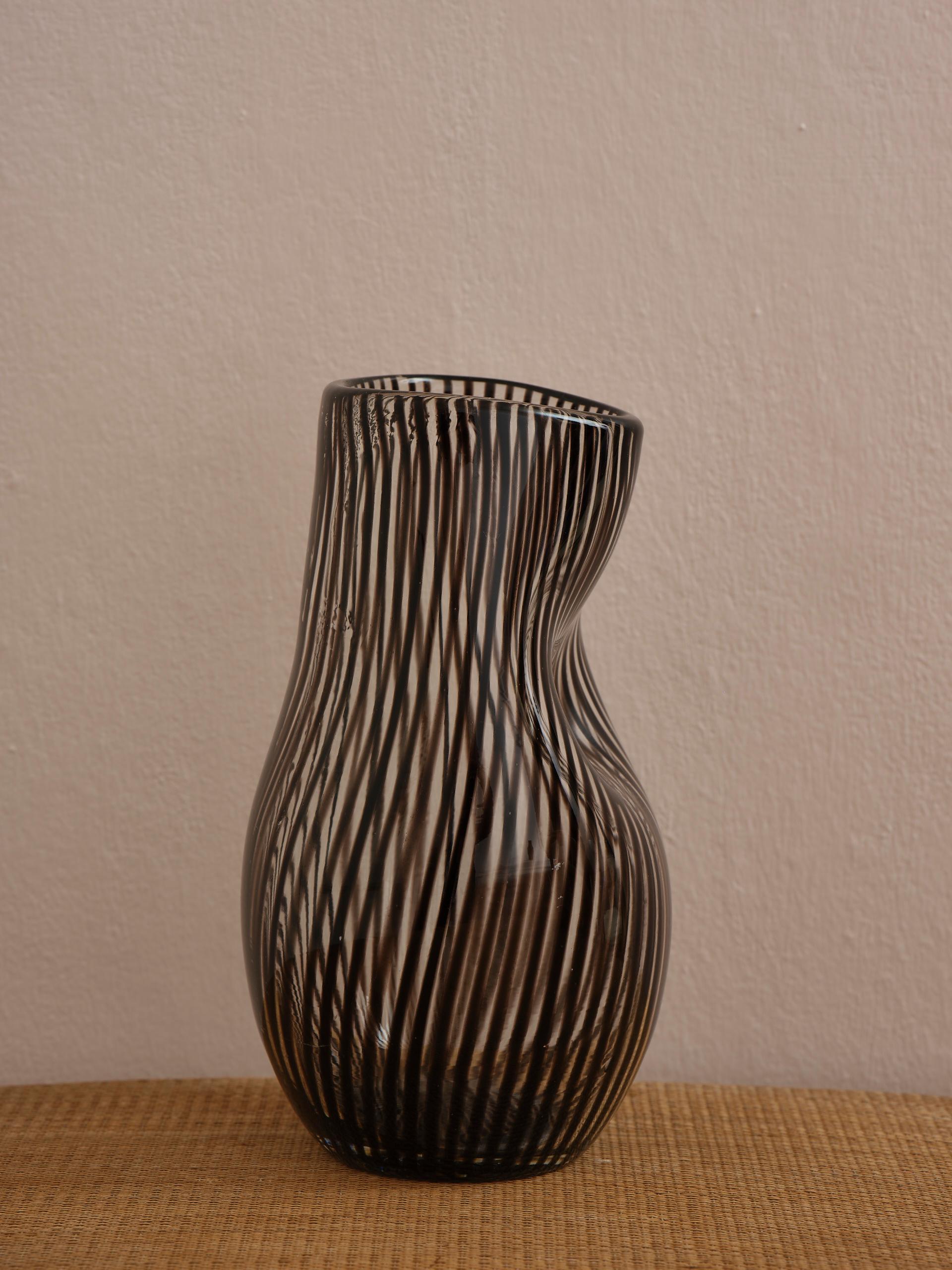 There’s nothing straight about this Swedish midcentury heavy striped vase in burgundy and clear glass, mouth blown and hand shaped with the most beautiful shapes. 
A unique piece of craftmanship from the middle of the 20th century.
Height 23 cm (9.0
