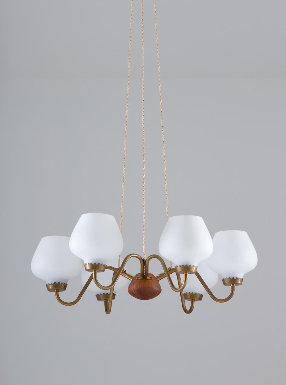 Midcentury pendant in brass, wood and frosted opaline glass manufactured by ASEA and attributed to Hans Bergström, Sweden, 1940s.
This great looking pendant is made with high quality and great details. It features six-light sources, hidden by