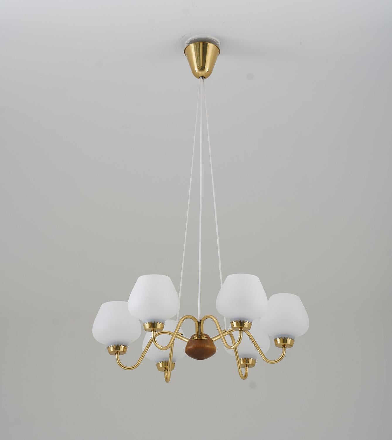 Midcentury pendant in brass, wood and frosted opaline glass manufactured by ASEA, Sweden, 1940s.
This great-looking pendant is made with high quality and great details. It features six light sources, hidden by frosted opaline glass shades. The