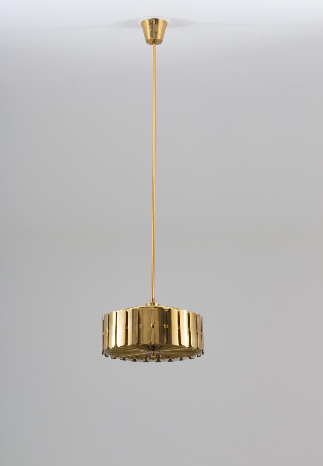 Rare pendant by Swedish manufacturer Konsthantverk Tyringe.
This impressive lamp is made of brass with a shade constructed by lamellae on different levels. It offers one light source, hidden by the diffuser that is in the same style as the rest of