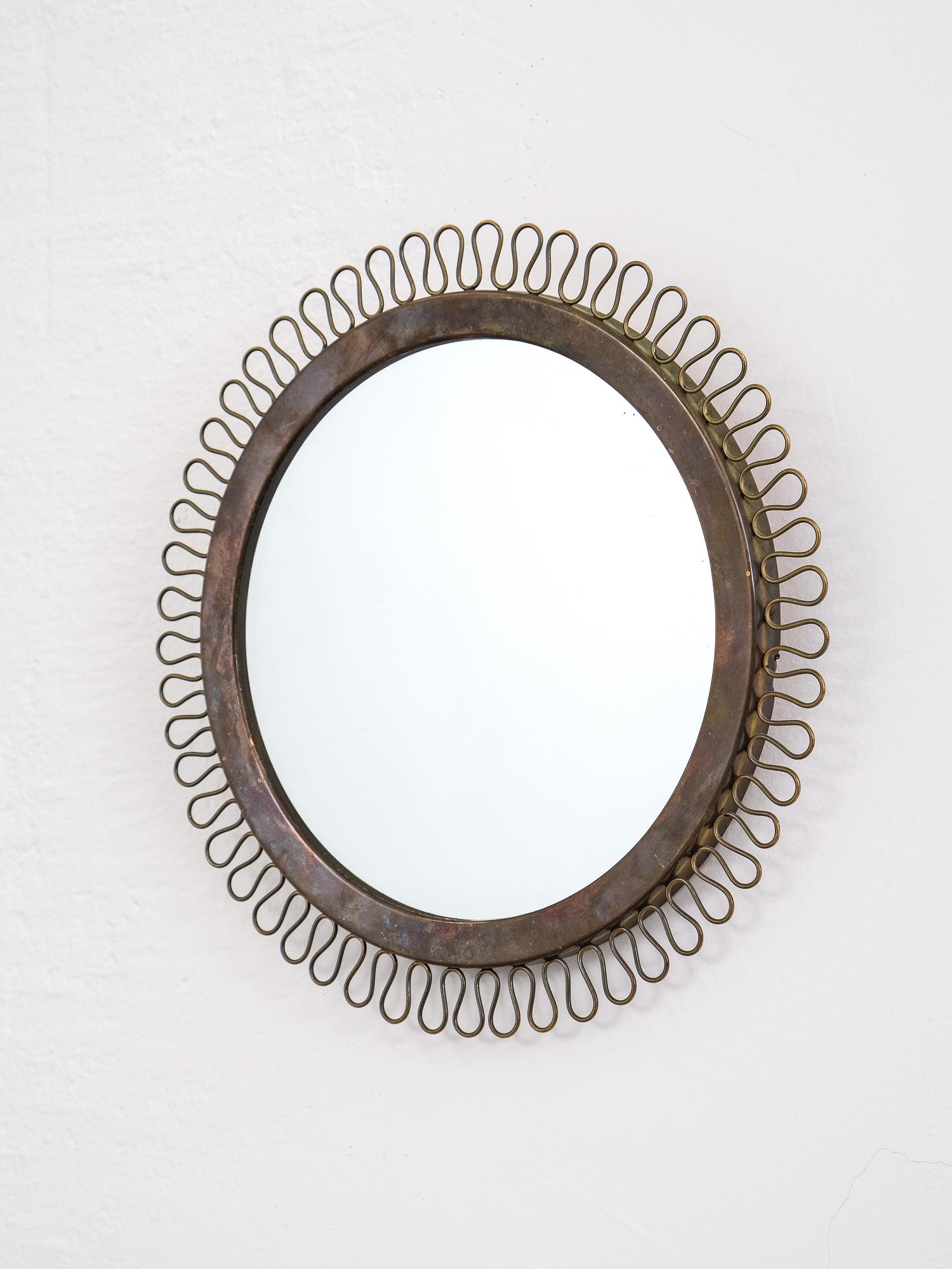 Pretty 1950s brass mirror in the manner of Josef Frank. Heavy patina on brass parts.

Measure: Diameter 32 cm.