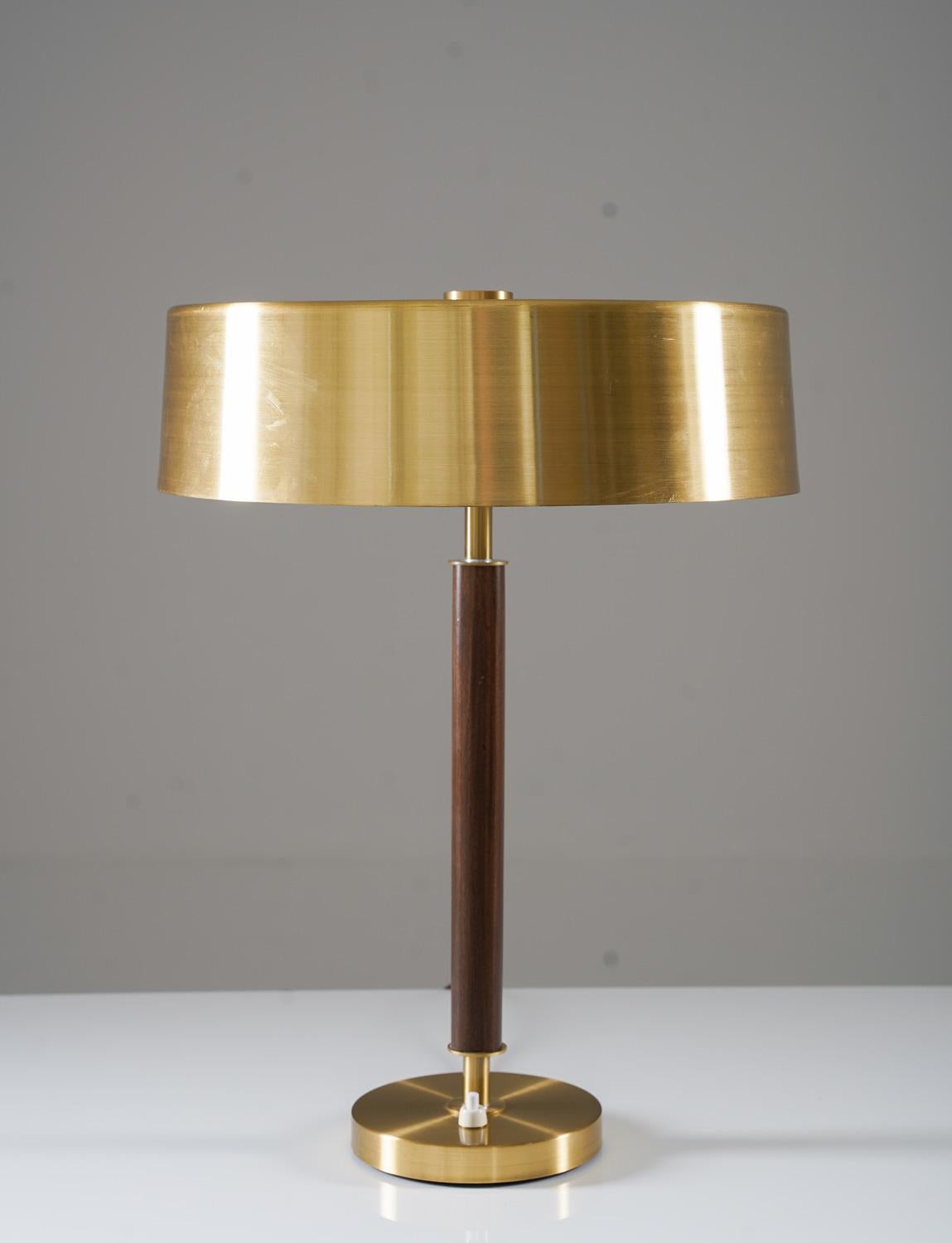 Table lamp in brushed brass and rosewood by Boréns, Sweden.
This impressive lamp consists of a stem surrounded by a shade and sitting on a foot in brushed brass. 
Condition: Very good original condition with a few scratches and minor dents.