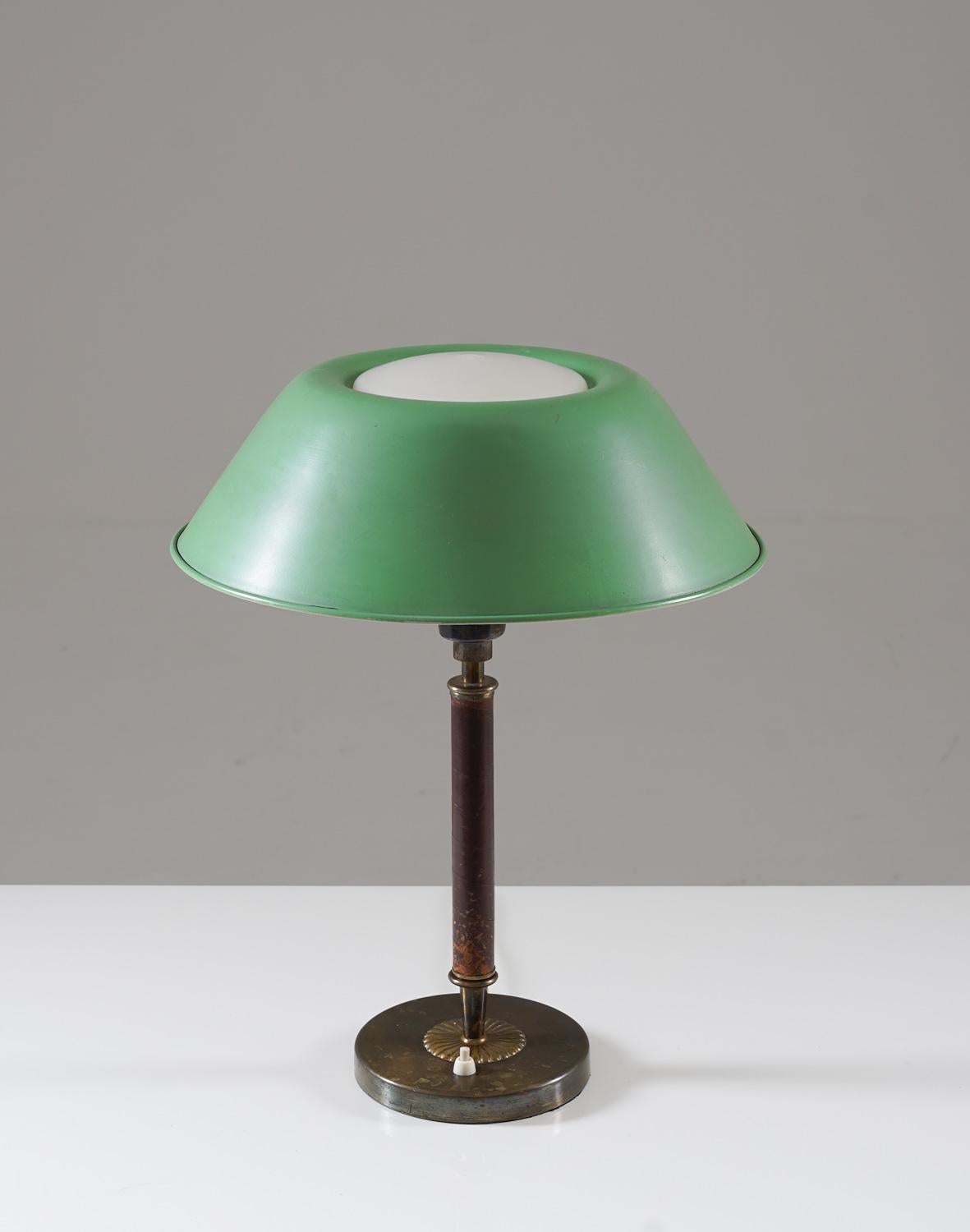 Rare lampe de table en laiton, cuir, verre et métal, très probablement fabriquée en Suède, dans les années 1930.
Cette lampe élégante a été fabriquée pendant l'ère moderne suédoise et est de très haute qualité. Il se compose d'un lourd pied en