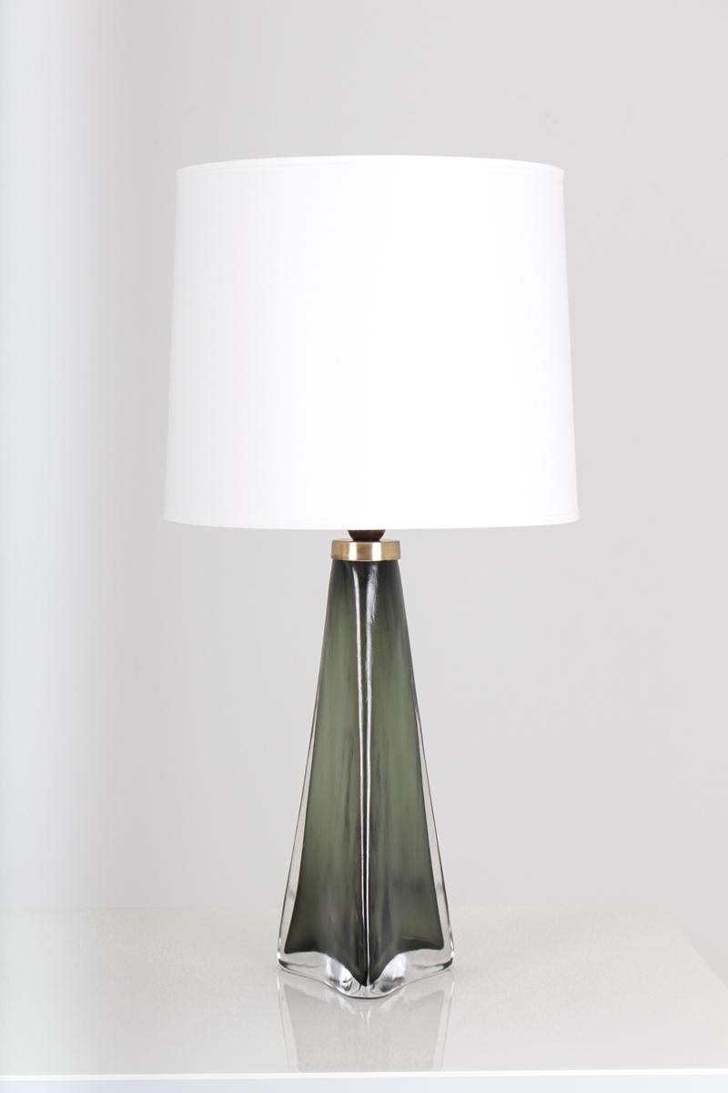 A pair of large table lamps in crystal, model RD1319 by Carl Fagerlund for Orrefors, Sweden. 
The lamps are triangular shaped with stunning olive green color.
Condition: Excellent original condition with signs of age and use on the brass