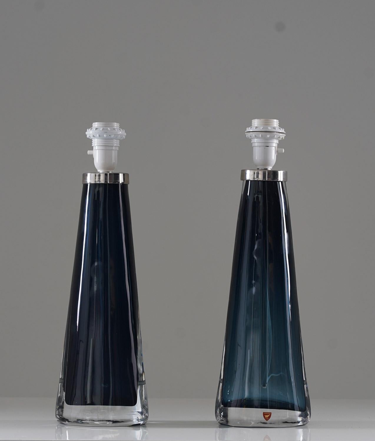 A pair of table lamps in crystal, by Carl Fagerlund for Orrefors, Sweden. 
The lamps are oval-shaped with stunning deep-blue color.
Condition: Very good original condition. The transparency of the glass differs a bit.
Height including socket: 44