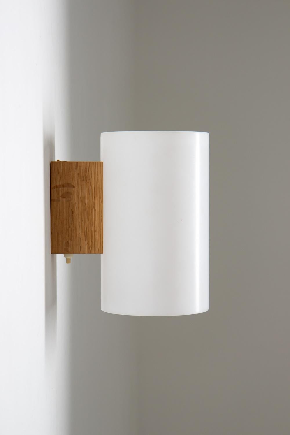 Add a touch of Scandinavian style to your home with these beautiful wall lamps by Uno & Östen Kristianson for Luxus, Sweden. The lamps are made of oak and feature white plexi shades that diffuse the light, creating a warm and inviting ambiance. The