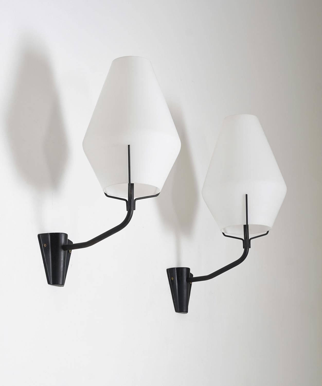 Wall lights manufactured by ASEA, Sweden, circa 1950.
Each lamp features one light source, hidden by a large frosted opaline glass shade. The shades are elegantly kept in place by three thin metal rods. 

Condition: Very good original