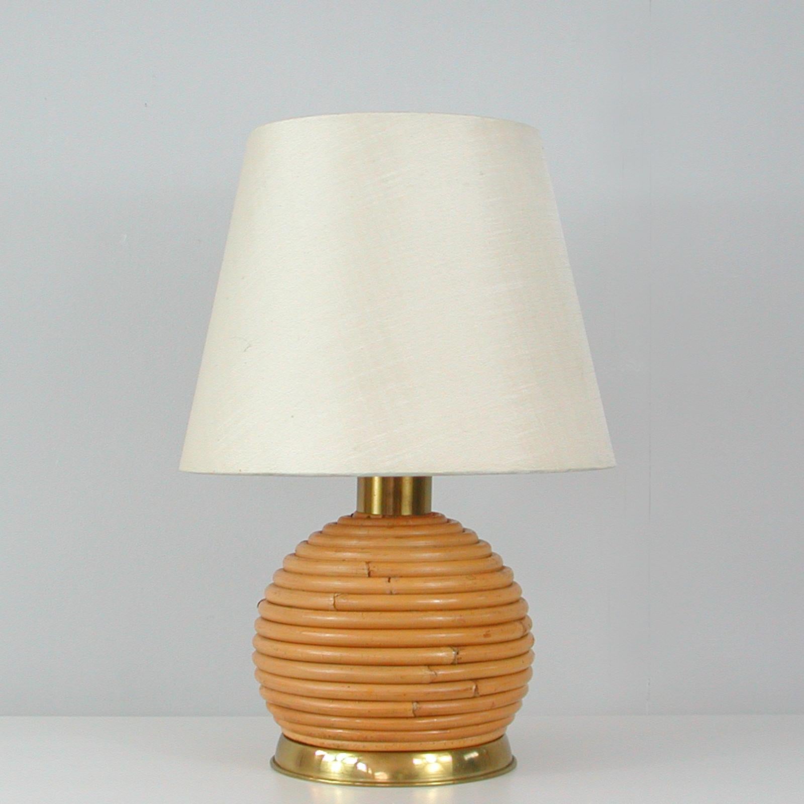 Cette lampe de table inhabituelle a été conçue et fabriquée en Suède dans les années 1960. Il est doté d'une base en rotin ou en osier en forme de globe et de ferrures en laiton. L'abat-jour original est en soie de couleur crème.

Bon état