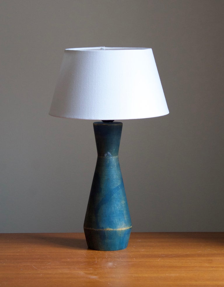 A solid wood table lamp, designed and produced in Sweden, c. 1950s. Hand-painted in blue. 

Stated dimensions exclude lampshade. Height includes socket. Sold without lampshade.