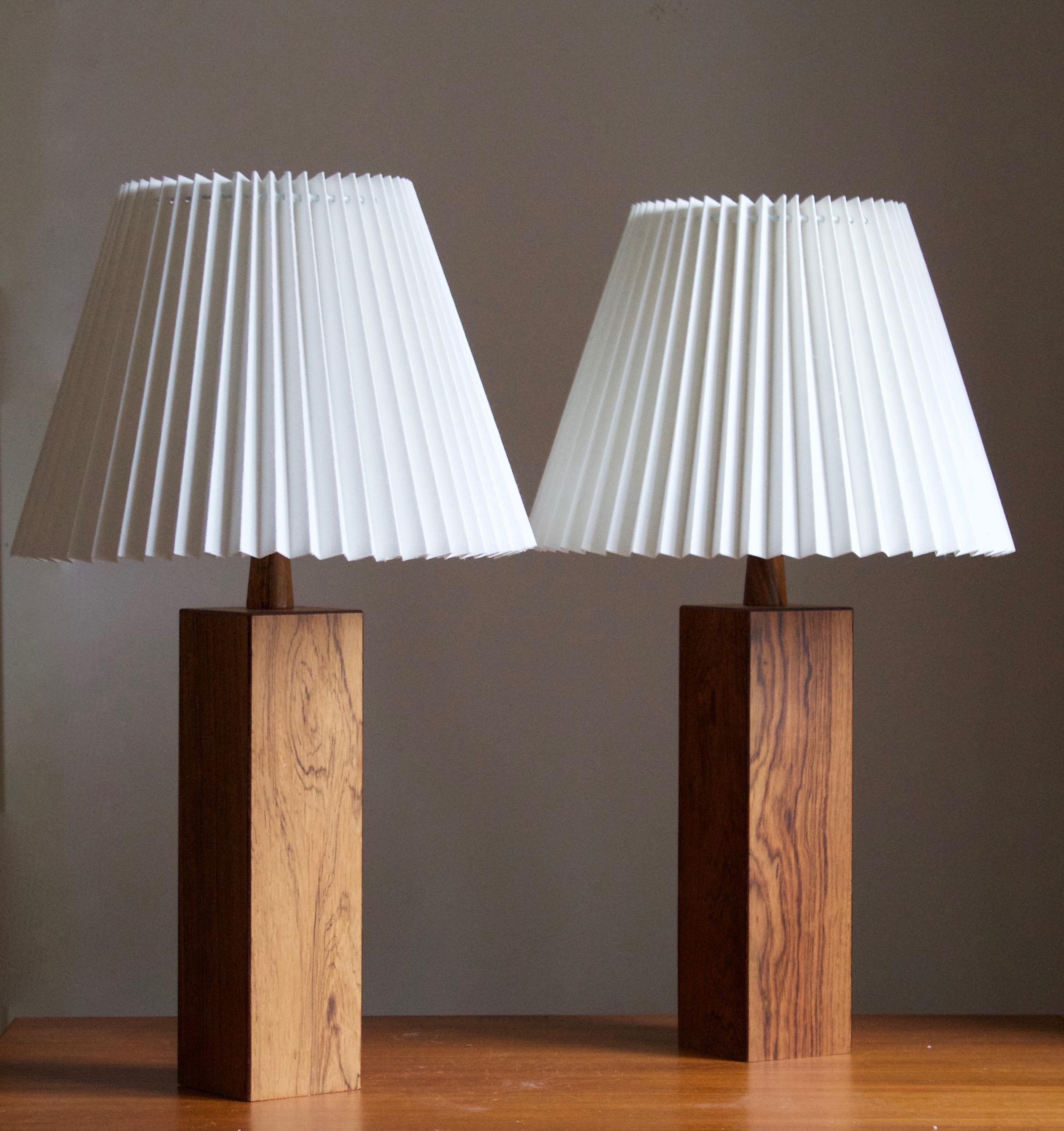 A pair of sizable rosewood table lamp, designed and produced in Sweden, c. 1950s-1960s. 

Stated dimensions exclude lampshade. Height includes socket. Sold without lampshade.