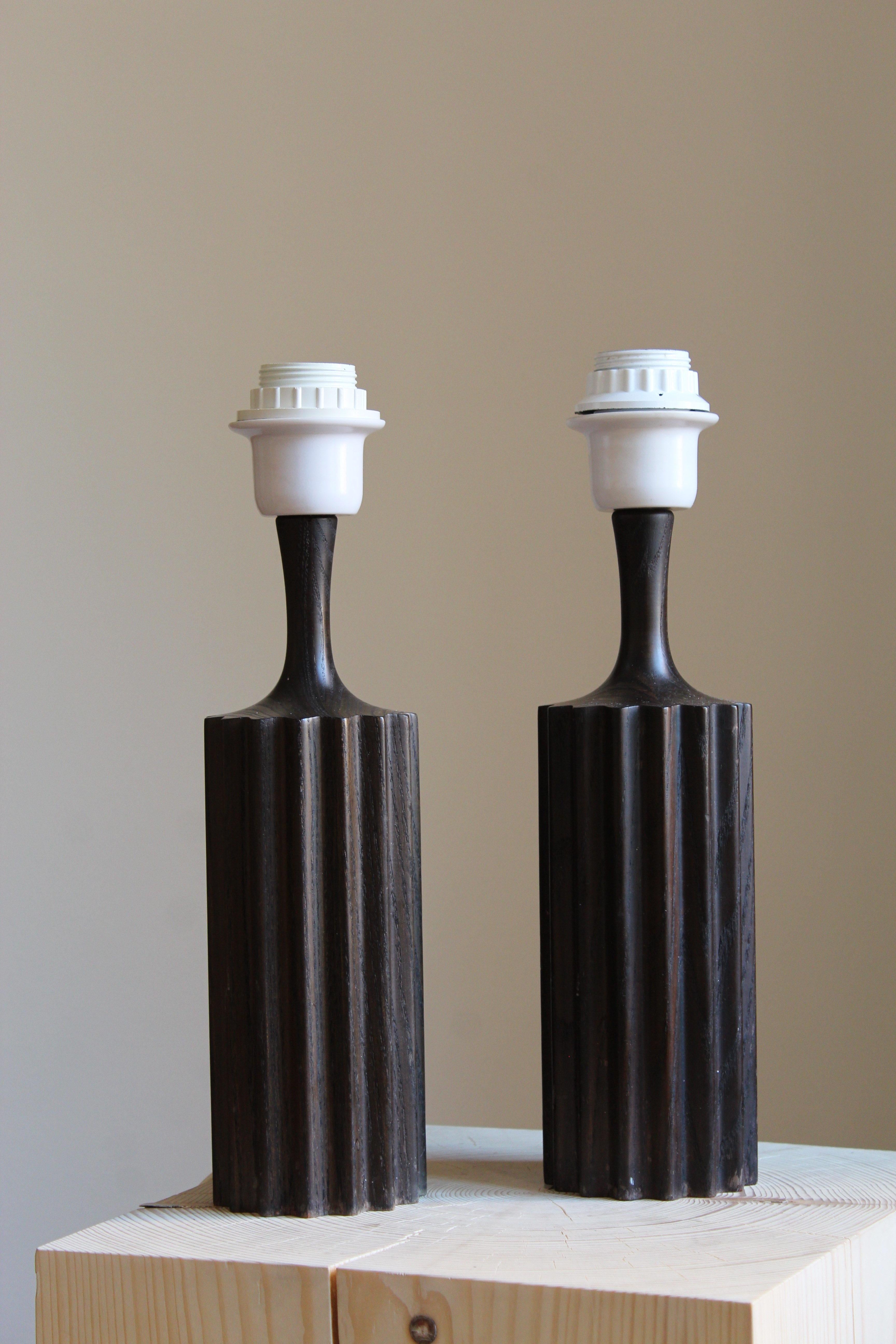 A pair of table lamps. Designed and produced in Sweden, 1960s. Features stained solid pine. Sold without lampshade.