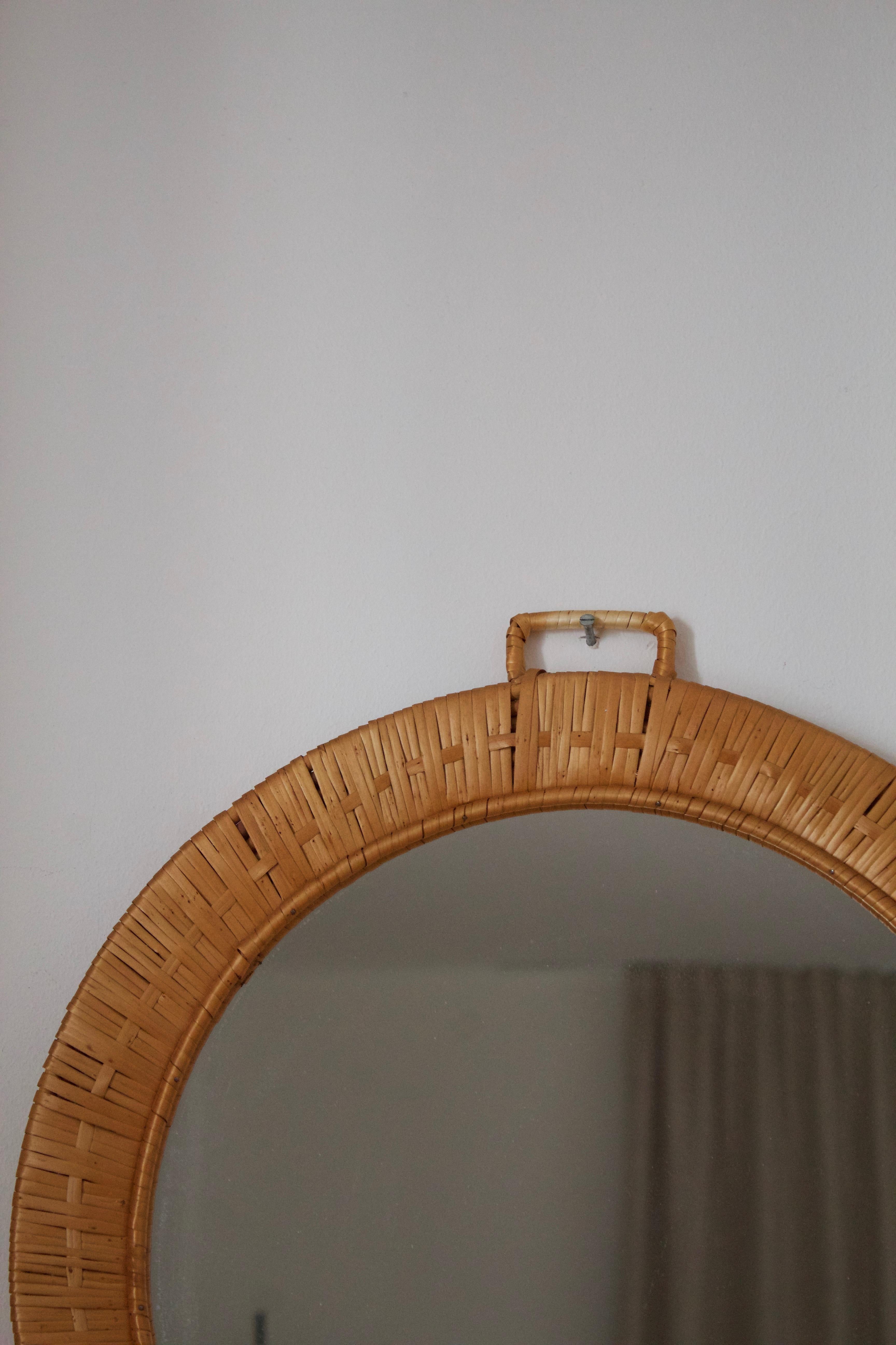 A round wall mirror. Designed and produced in Sweden, c. 1950s-1960s.
 
 