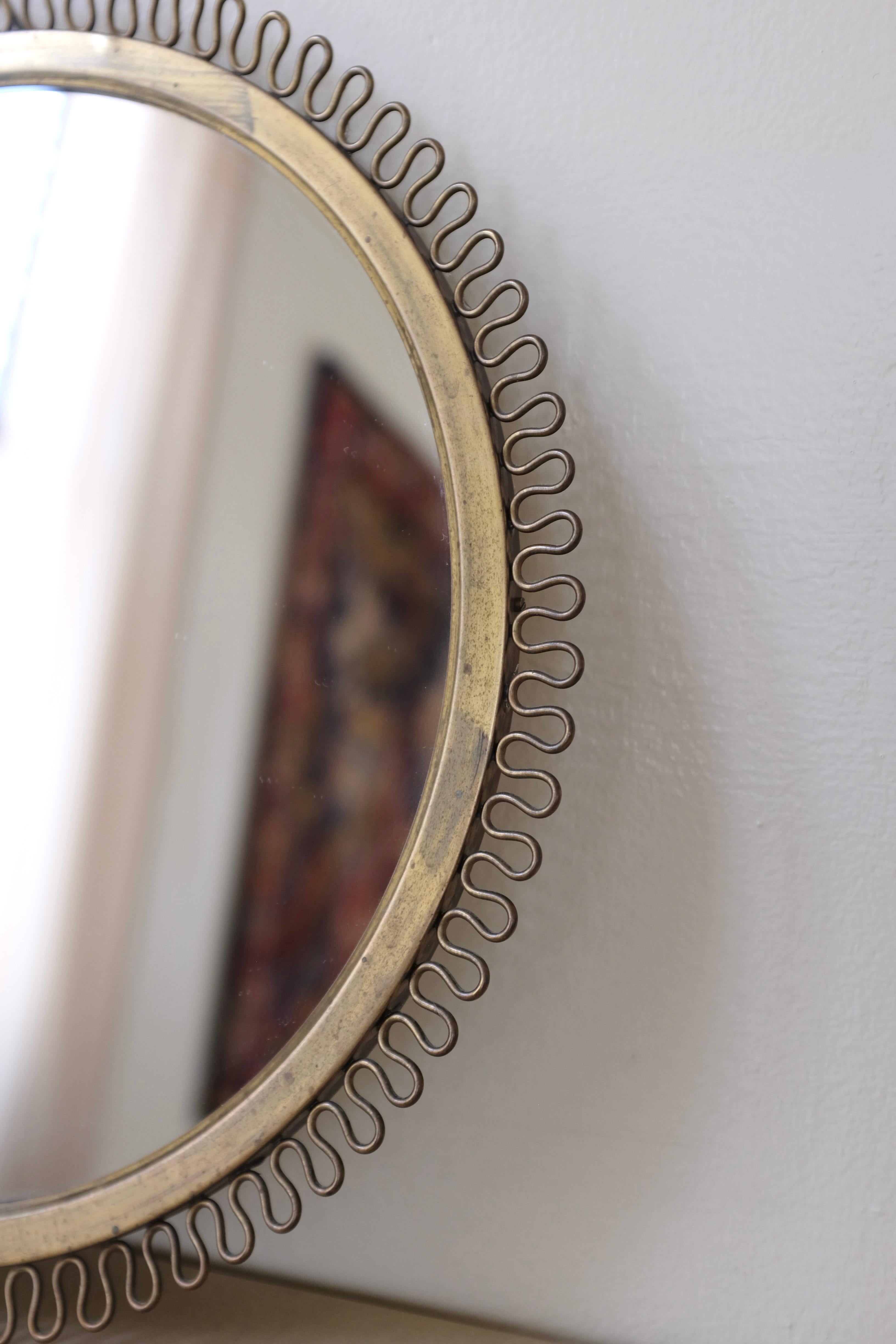 1950's Brass mirror in the manor of Josef Frank, Firma Svenskt Tenn. Beautiful filigree design around the edges. Age appropriate wear to the brass and glass och overall in a very good condition.

Dimensions: D 13 in x H 0.5 in