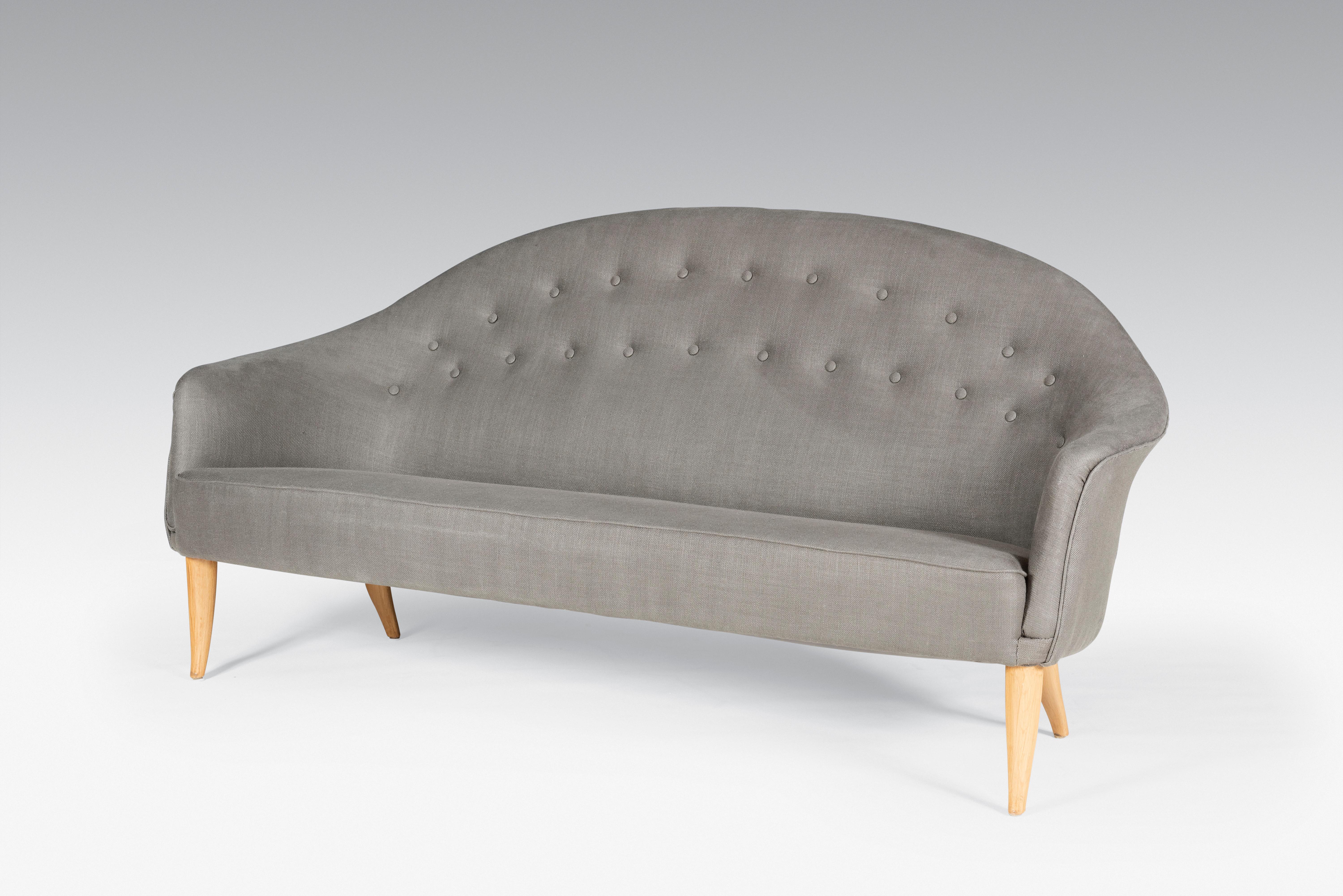 Kerstin Horlin Holmquist is a Swedish designer. This sofa was made for Nordiska Kompaniet in the 1950's. This was part of her Paradise design. This is the larger version. It features a soft curved line of the back and tapered and curved beech legs.