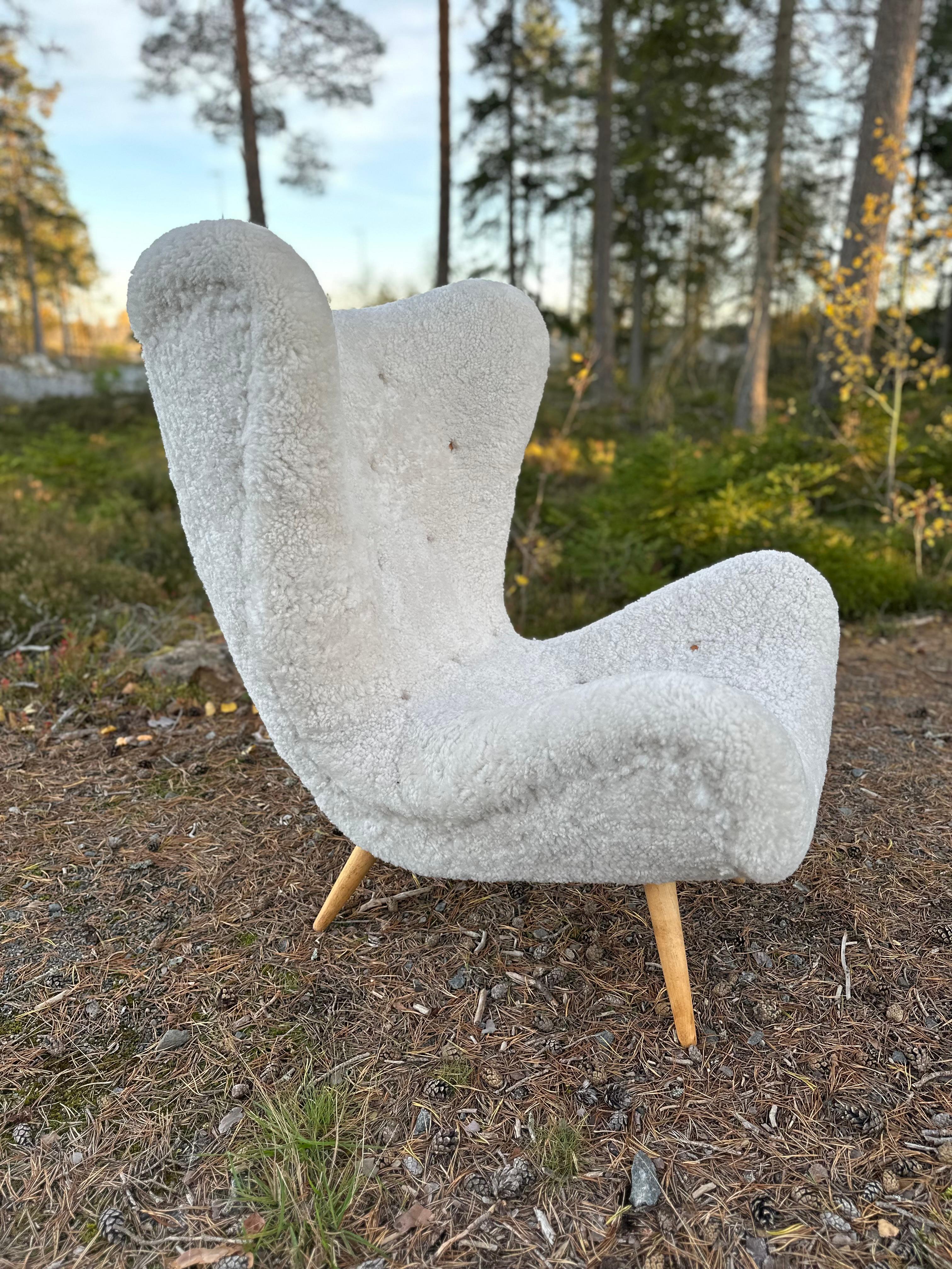 Swedish Modern armchair from the mid-century. 

One of only two ever documented, which make the chair very rare. Amazing character with its curves of big proportions. 

Legs in beech, covered in a cream-white sheepskin with deep-stitched leather