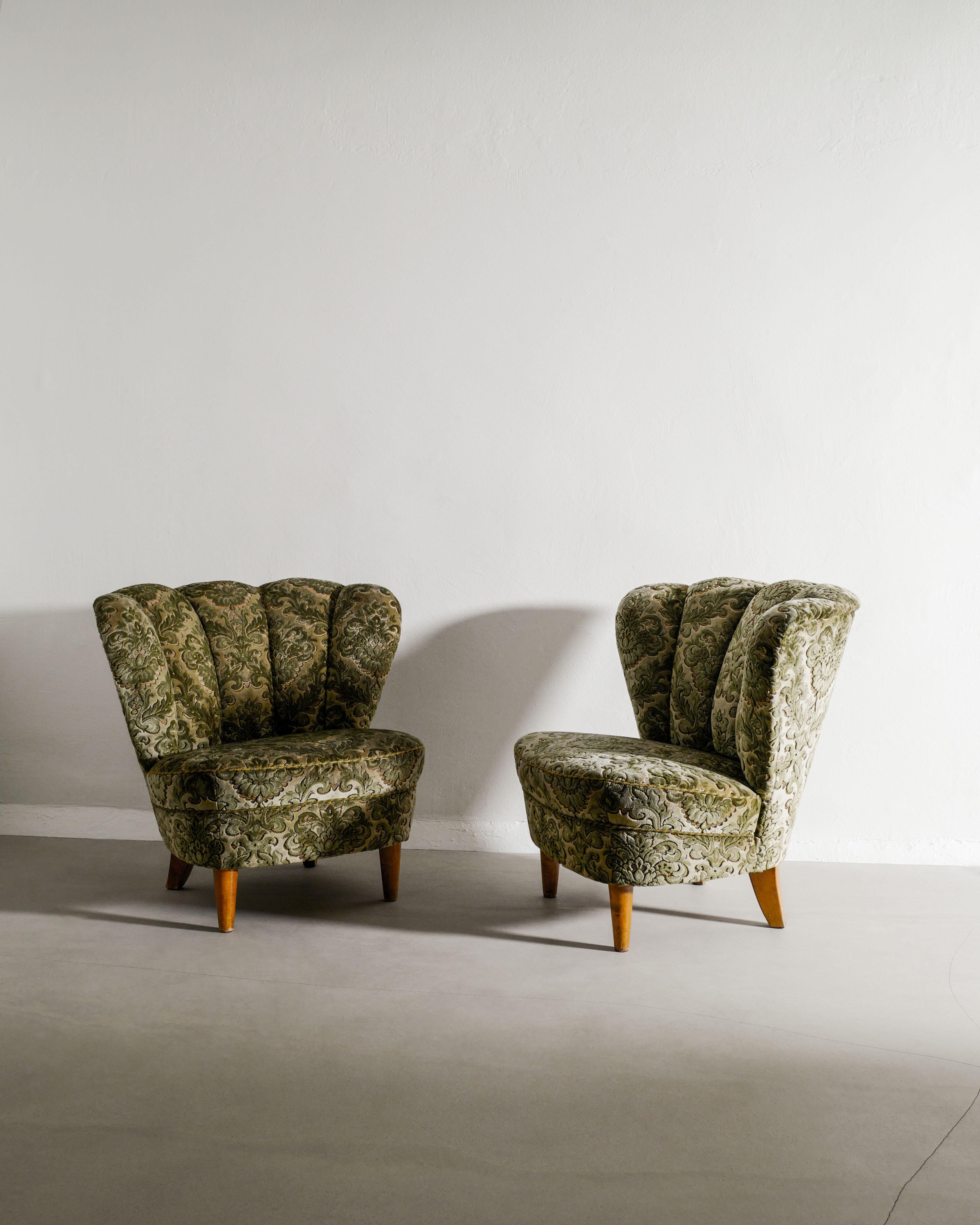 Rare pair of Swedish mid century modern armchairs attributed to Gösta Jonsson / Otto Schulz in beech wood feet and original green floweral fabric produced in Sweden, 1940s. In good original condition.

Dimensions: H: 75 cm / 29.50