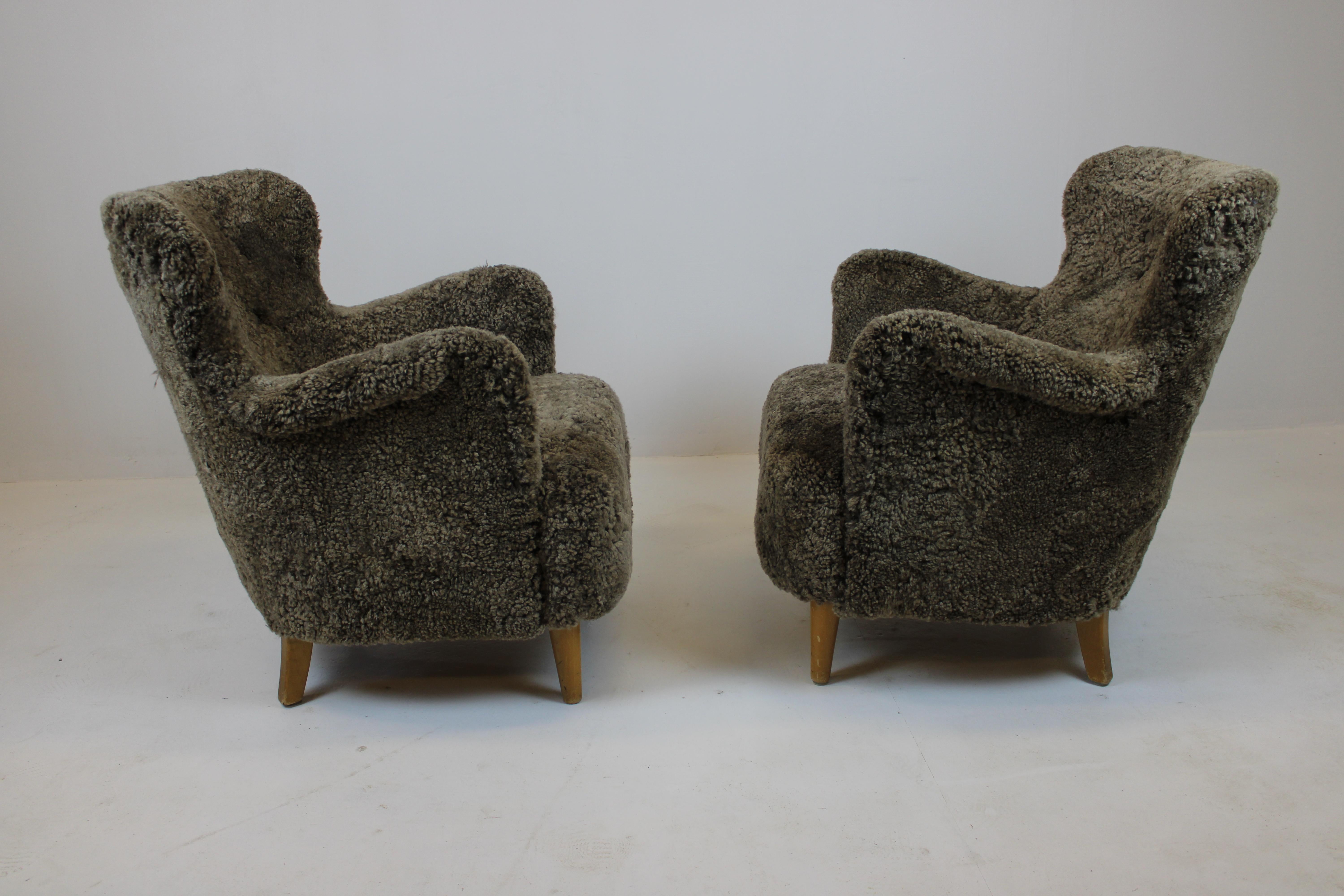 Amazing Swedish mid-century design armchairs.
Upholstered in highest quality sheepskin from New Zealand. 

“Sahara”-coloured sheepskin, which in real life appearance strikes to be a bit more brown than a camera can show.

Newly renovated and ready