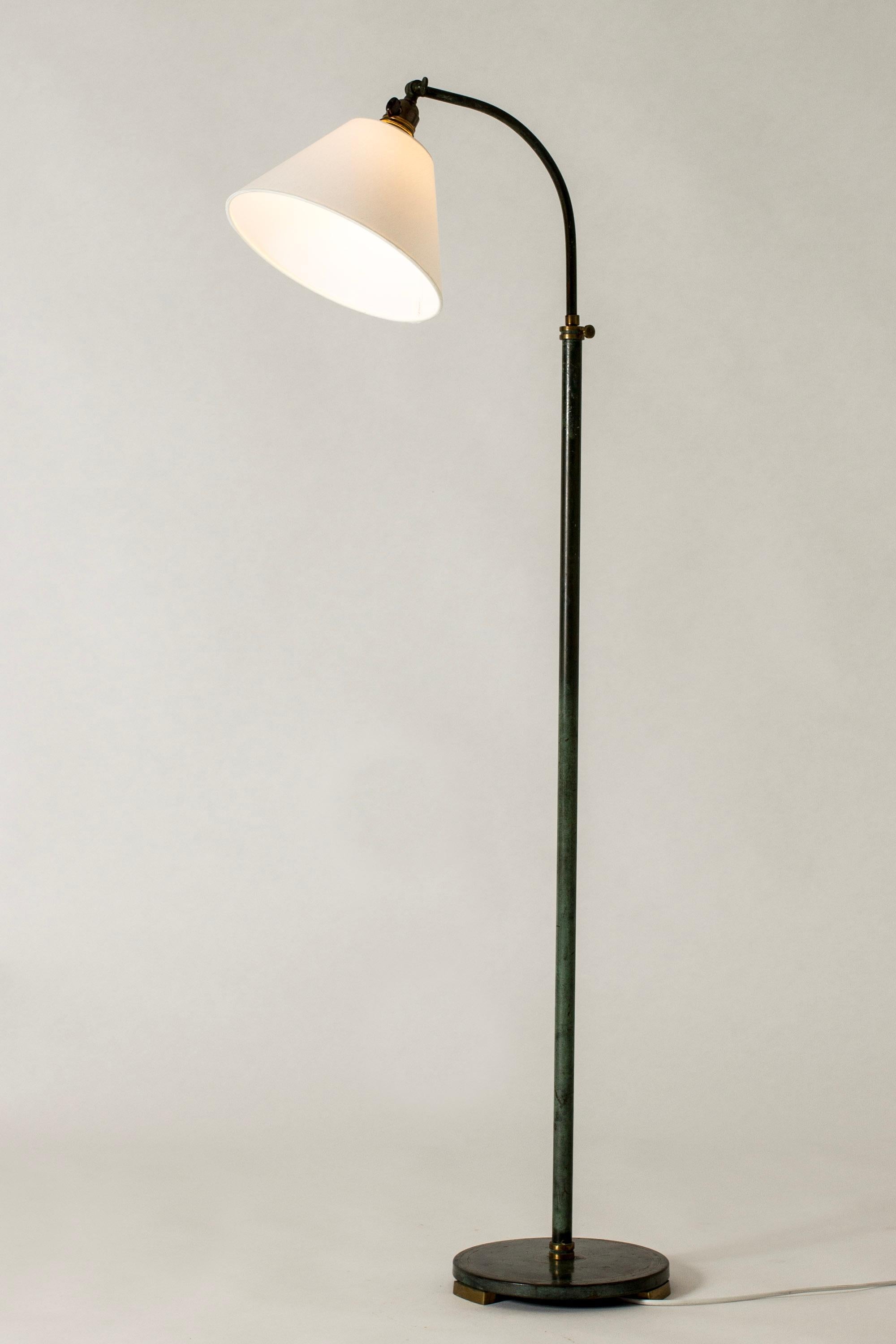 Elegant Swedish Art Deco floor lamp, made from bronze with deep green patina. Burnished gold details and decor. Height is adjustable.