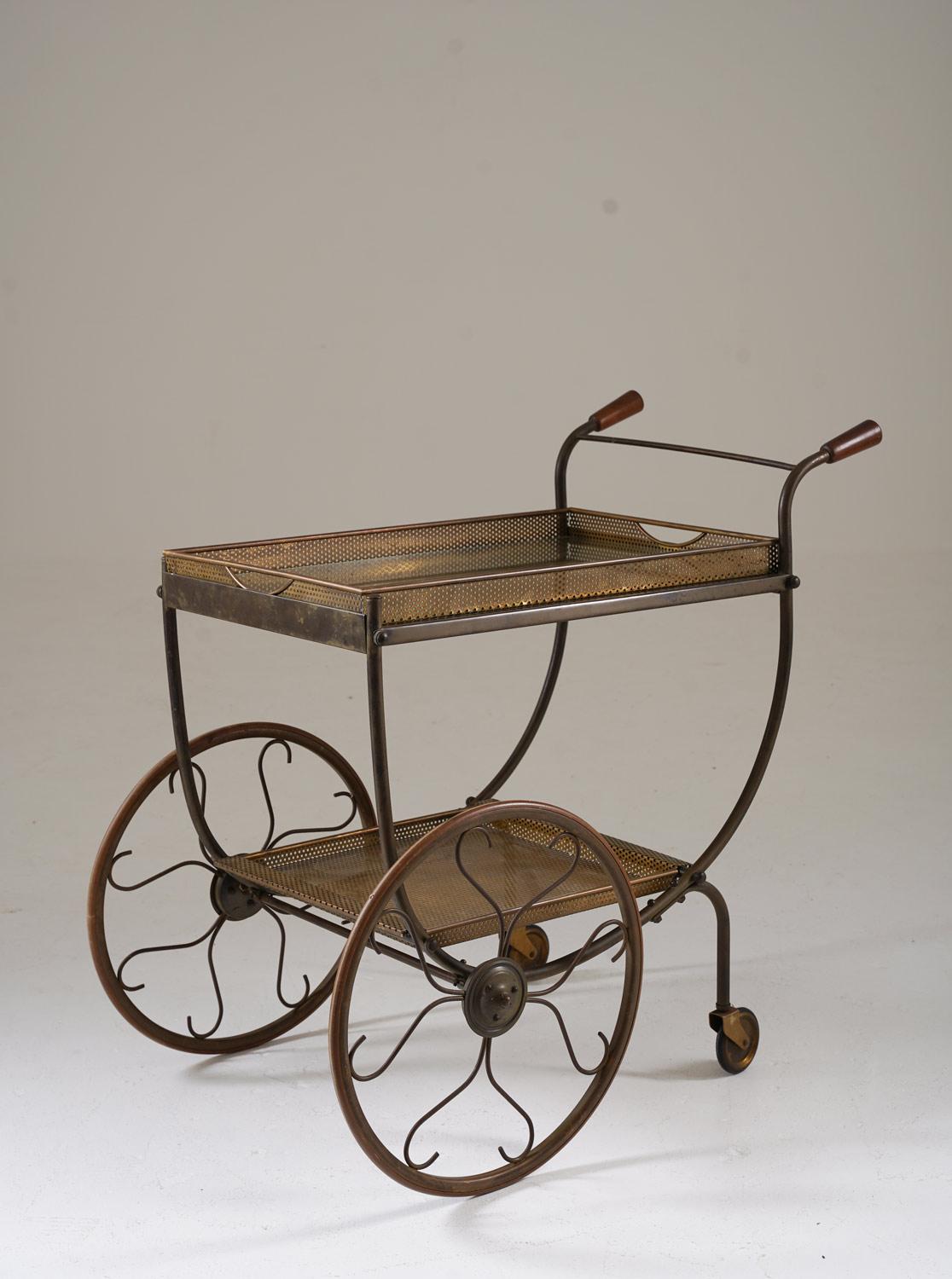 Magnifique chariot de service vendu chez Svenskt Tenn en Suède vers 1950. Le chariot est en laiton avec des poignées en bois et des plaques de verre.

Condit : Très bon état d'origine avec une belle patine. 

Veuillez noter qu'il sera démonté pour