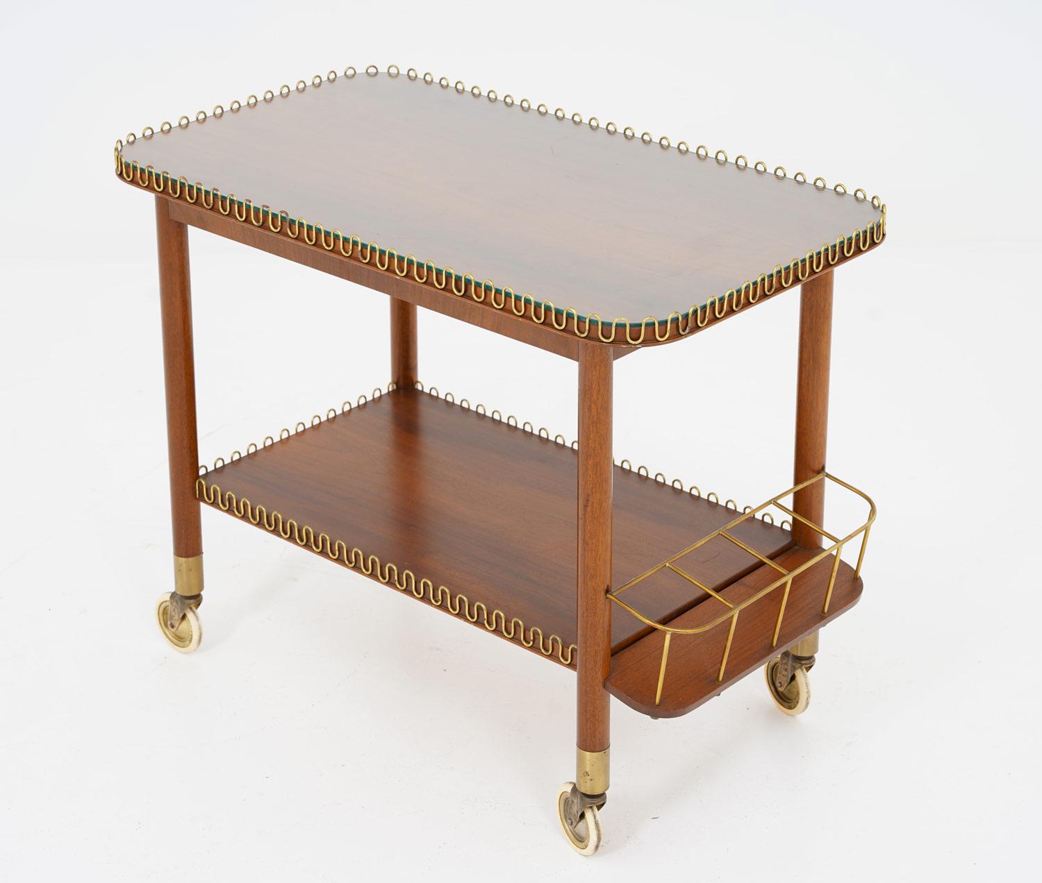 Beautiful design and well matched materials make this piece a good fit in a modern home. It consists of a frame in mahogany with beautiful details in brass and a glass table top.

Condition: Very good original condition.