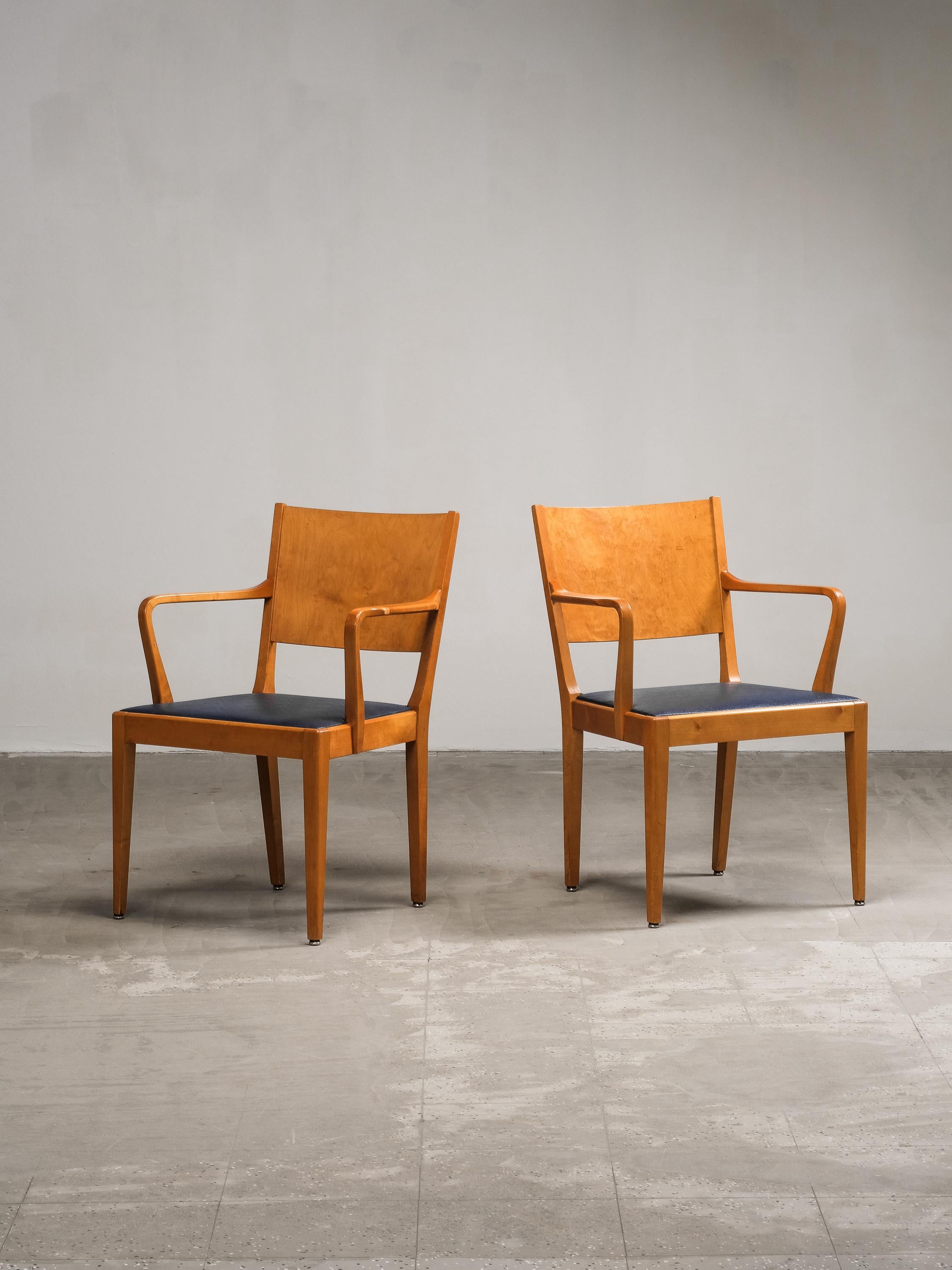 Crafted in Sweden during the 1940s, this elegant pair of armchairs showcases the refined sensibilities of Nordic functionalism. The sculptural frames are made from solid birch, featuring gently curved armrests and tapered legs that emphasize clean