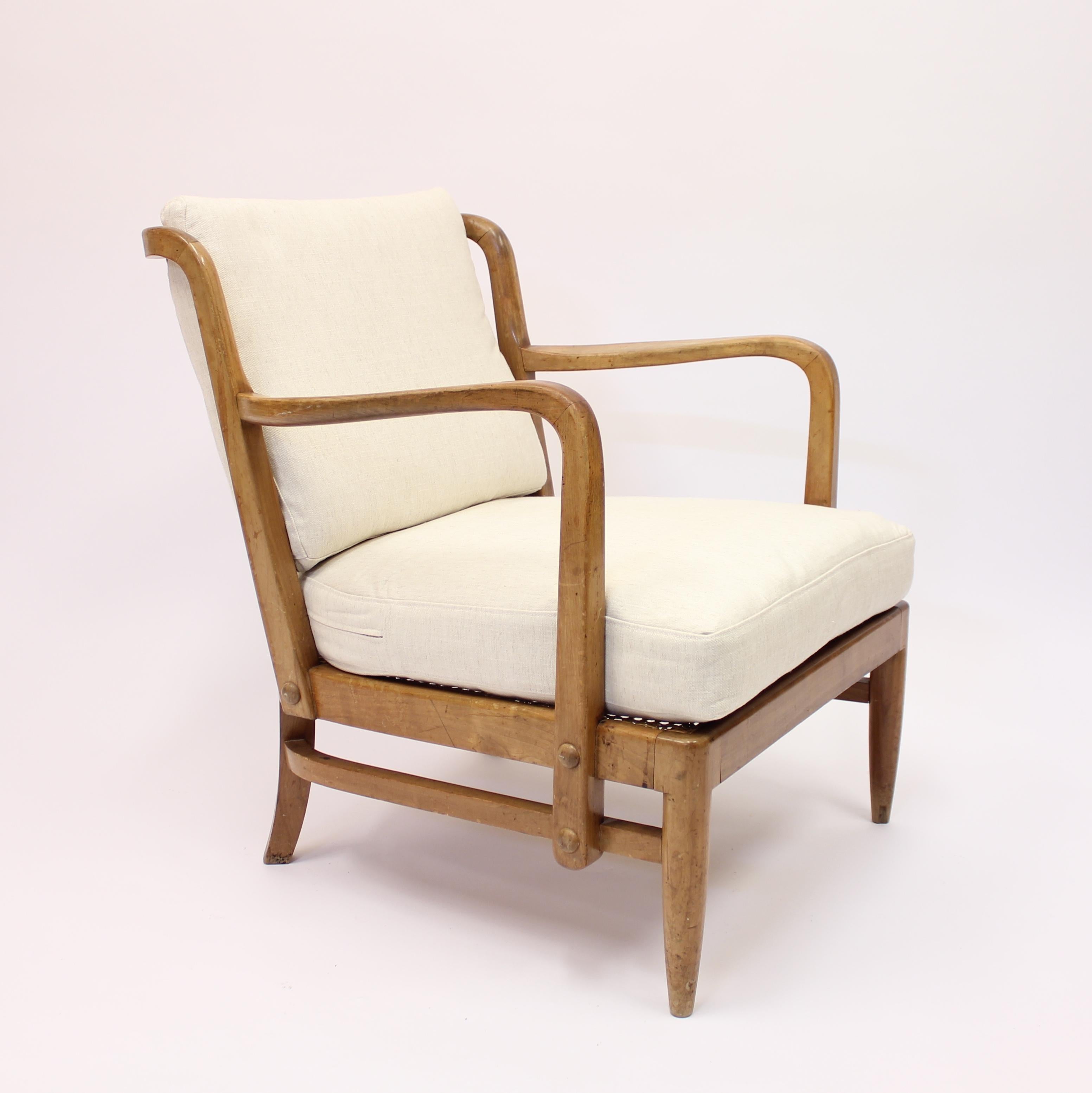 Very rare loung chair from ca 1940 in birch (or maybe elm) with new off-white fabric to both cushions. The pegs / stems at the backrest are made of bambu and the seat cushion is held up with a rattan bottom. It's attributed to Swedish / German