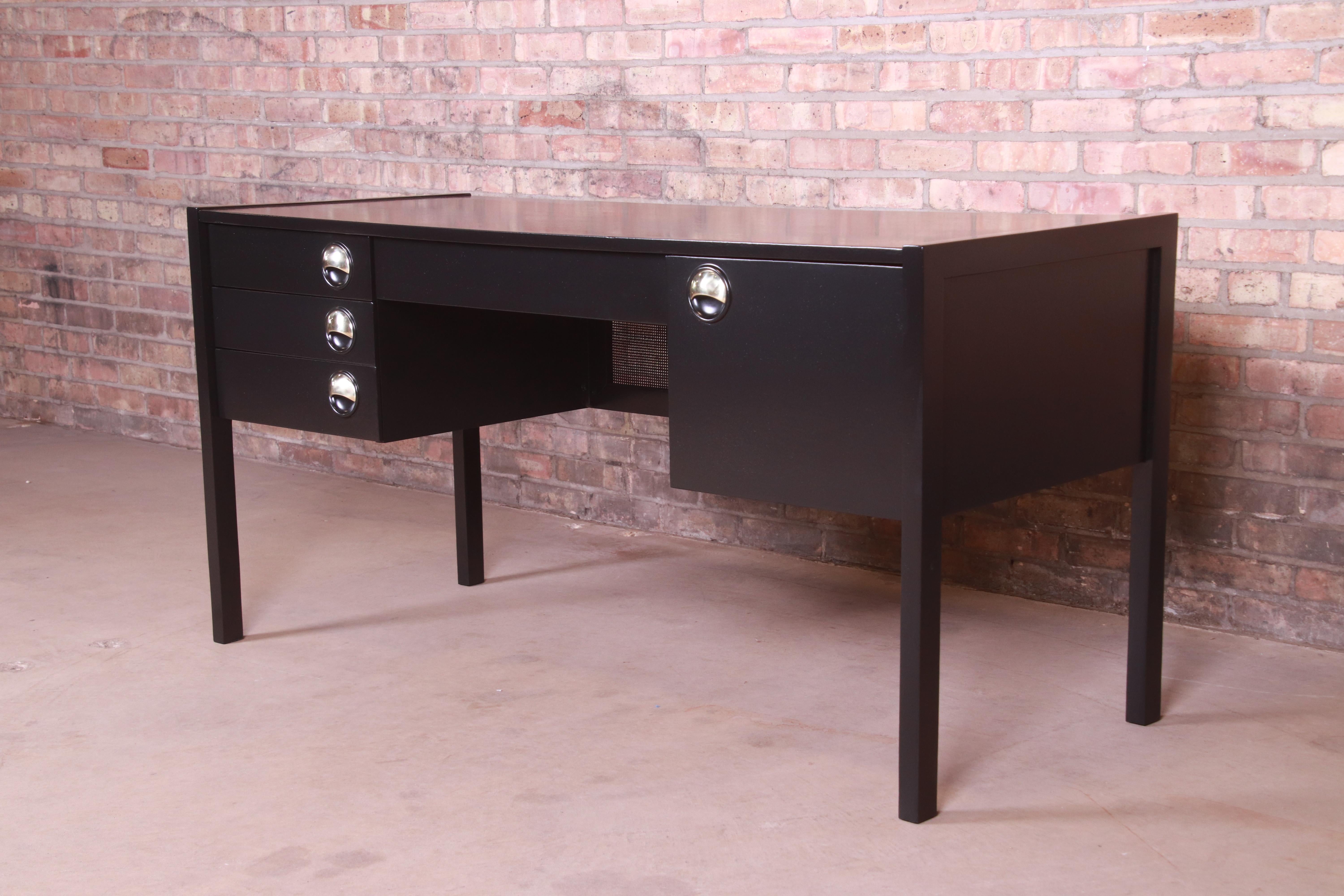 An exceptional midcentury Swedish modern writing desk

Sweden, circa 1960s

Black lacquered walnut, with caned modesty panel and original brass hardware.

Measures: 57.88