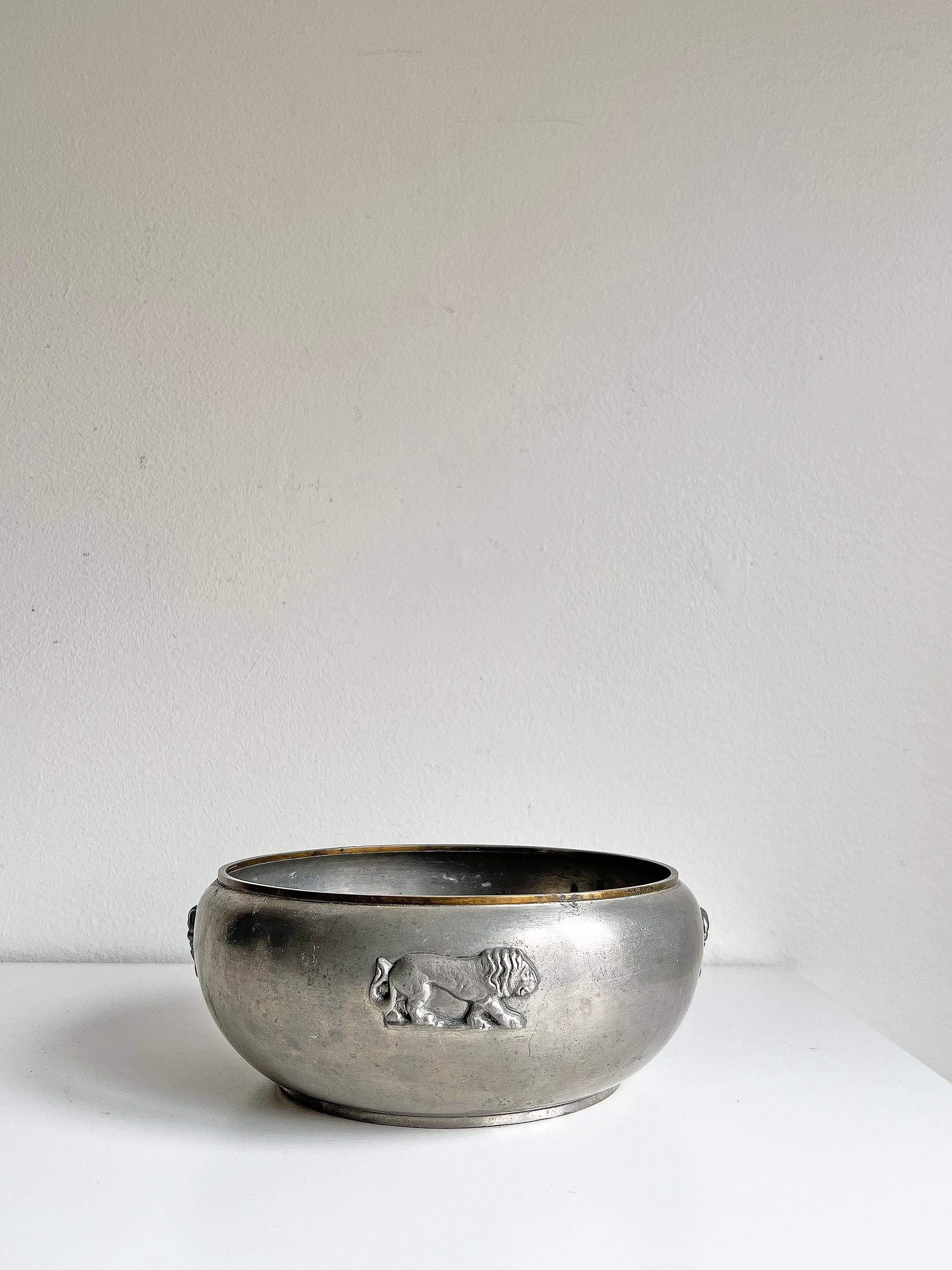 Very rare bowl in pewter with brass rim by GAB -1930.
Lovely piece decorated with lions and palm-trees. 
Signed with makers mark.

Wear consistent with age and use. 
Pewter and brass patina, marks, scratches and dents, uneven base as seen on