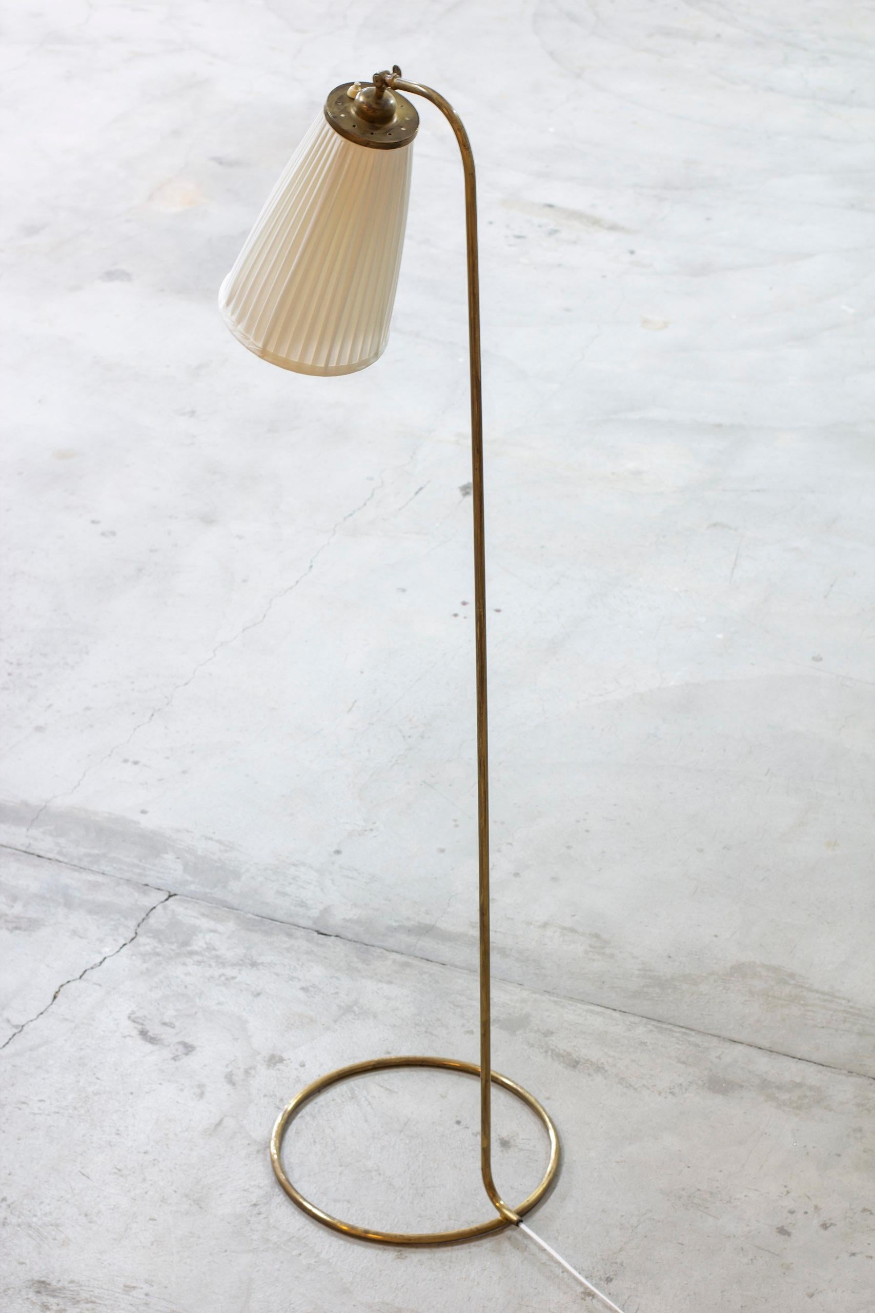 Rare Swedish modern floor lamp by unknown designer and manufacturer. Made from brass with a large hand pleated chintz lamp shade. Shade adjustable in angle. Light switch on top of the lamp shade in working order. Very good vintage condition with