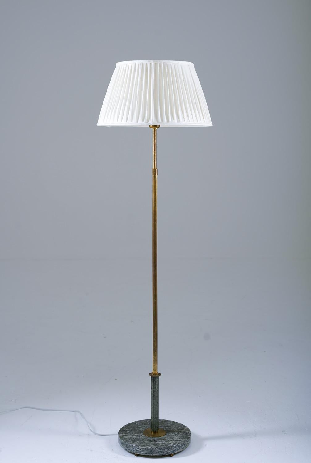 Scandinavian floor lamp manufactured in Sweden, 1930s.
Beautiful floor lamp made in beautiful materials. The foot is made of green marble, supporting the brass base, which has a marble-colored ornament. The height of the lamp is adjustable between