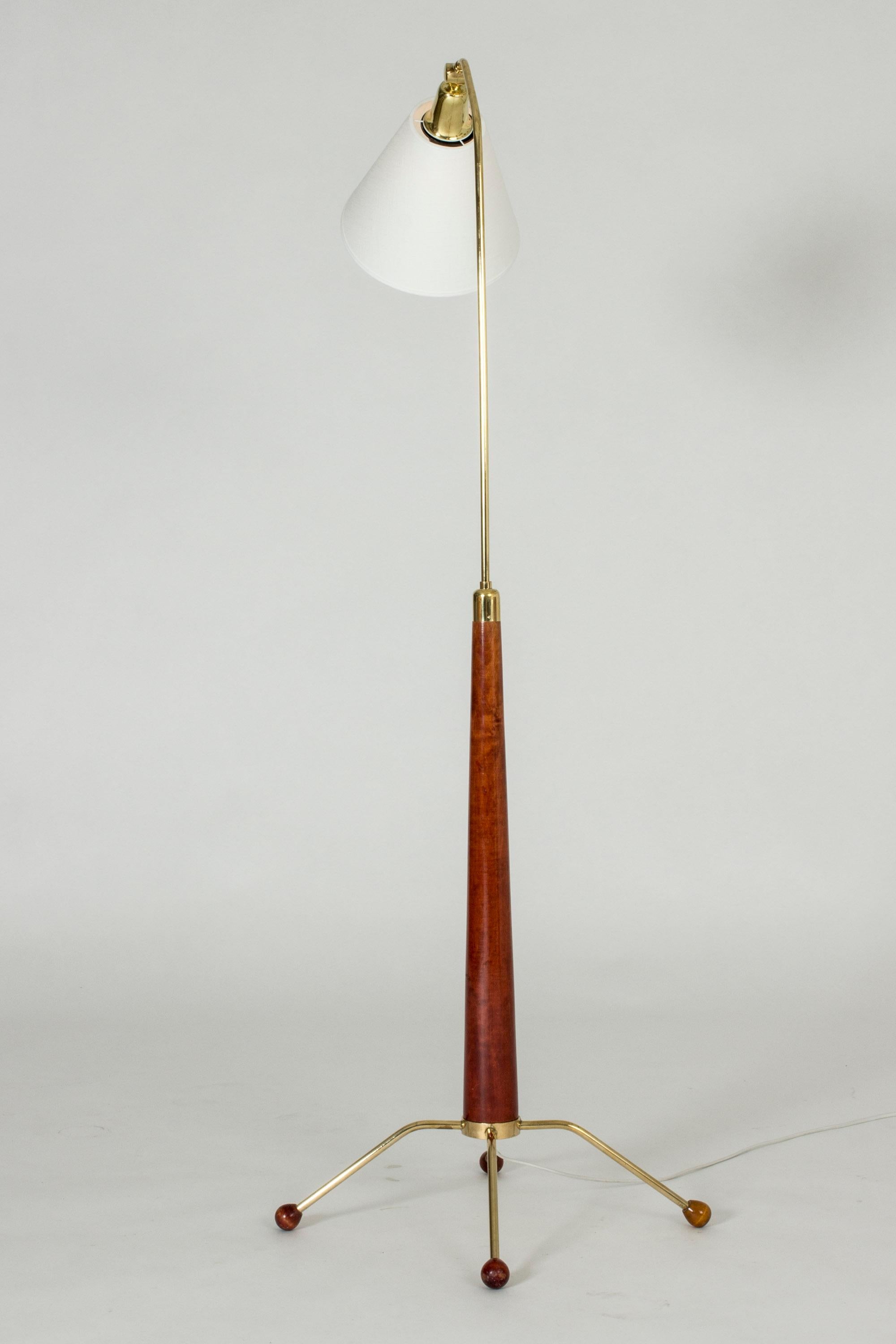 Cool floor lamp from Uppsala Armatur, made from brass with wooden details. Four feet with decorative, round chunky feet.