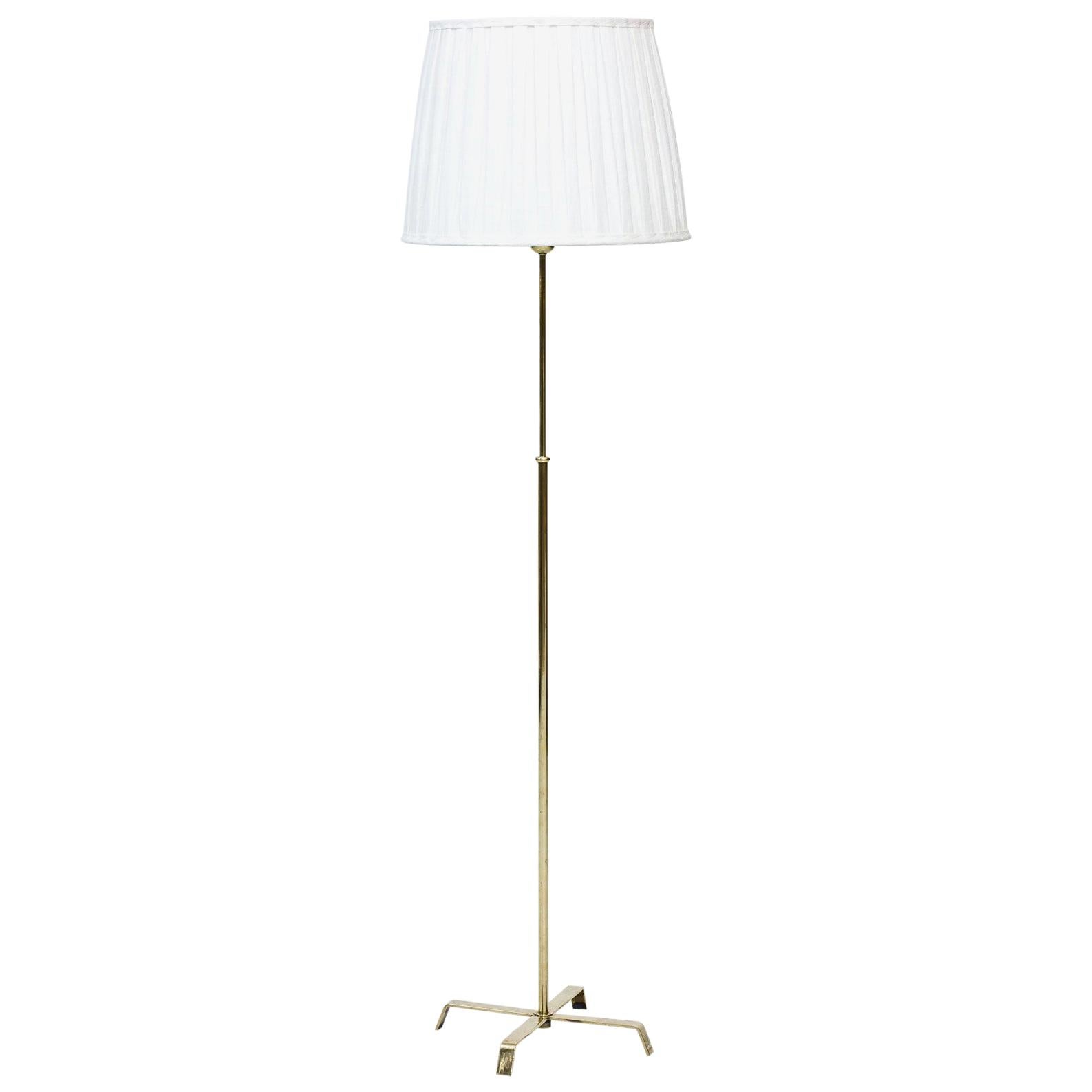Floor lamp manufactured in Sweden by Böhlmarks lamp fabric during the 1940s. 
Made from brass with hand pleated lamp shade in linen fabric. 
Adjustable height of the stem. Engraved on the base.