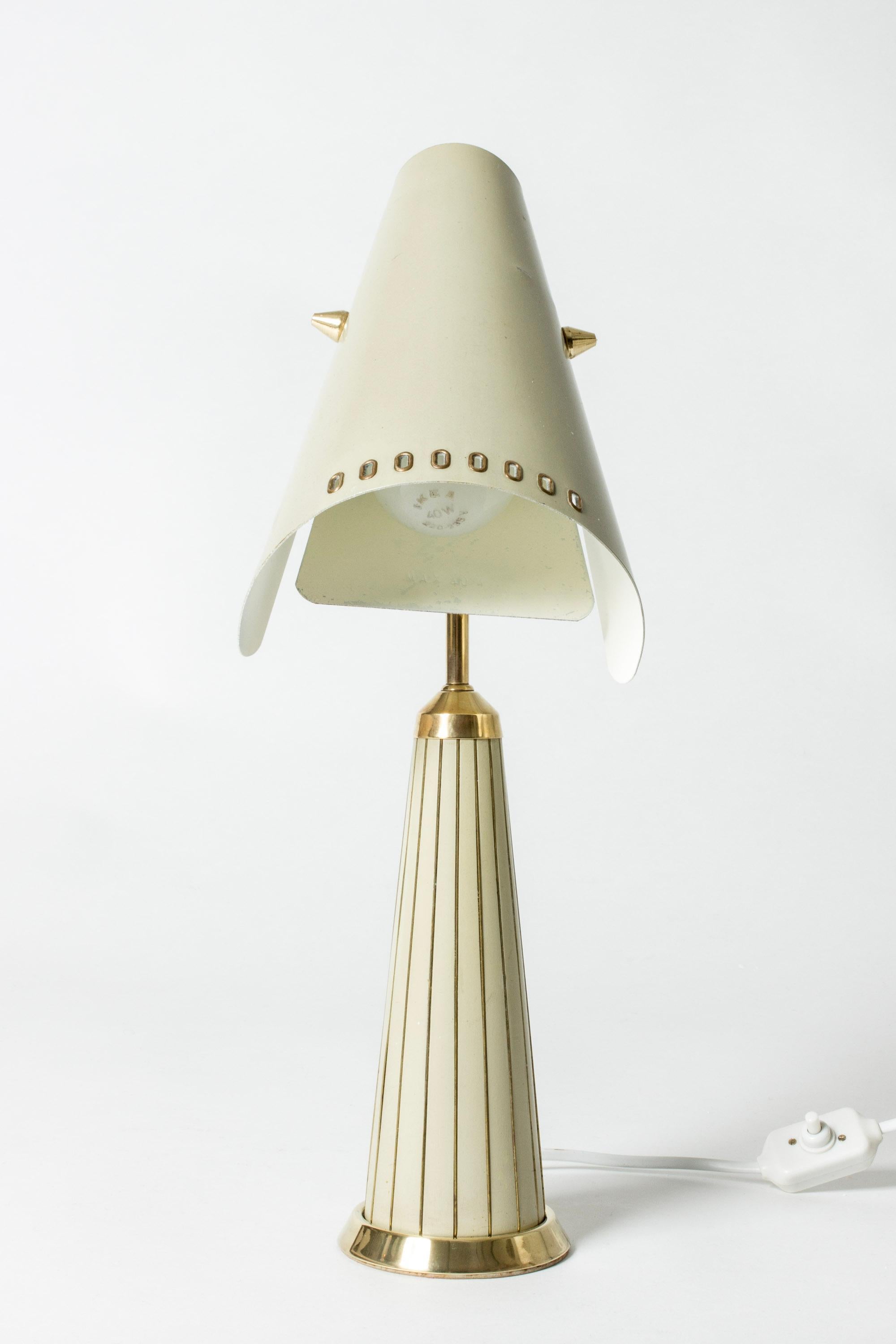 Very cool Swedish 1950s table lamp from Fåglavik, a small lighting firm in the south of Sweden. Fåglavik made small series of lighting with distinct artistic expressions. Made from cream lacquered metal with striking brass details.
