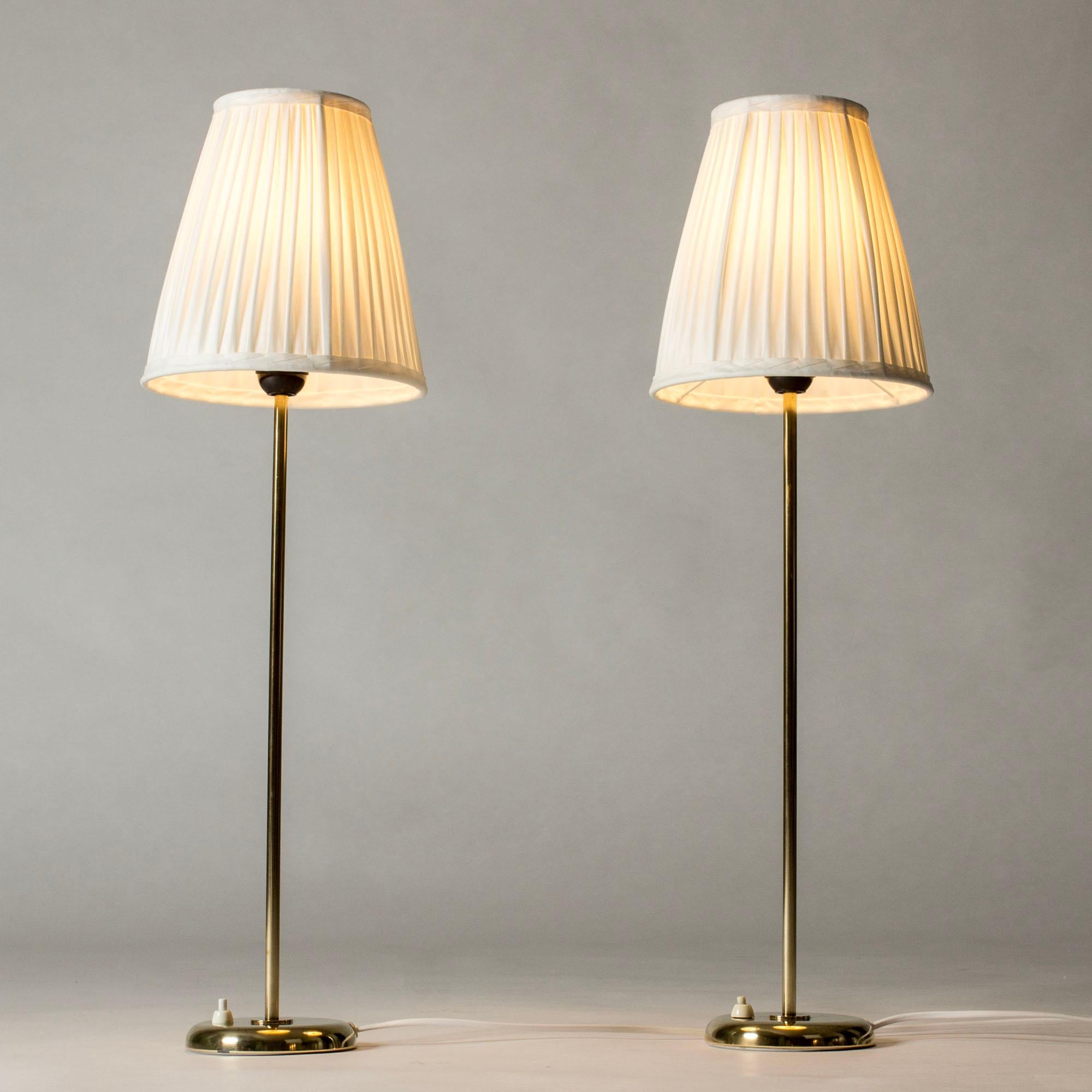 Pareja de elegantes lámparas de sobremesa de Böhlmarks, fabricadas en latón con un diseño alto y esbelto. Tonos plisados voluminosos.