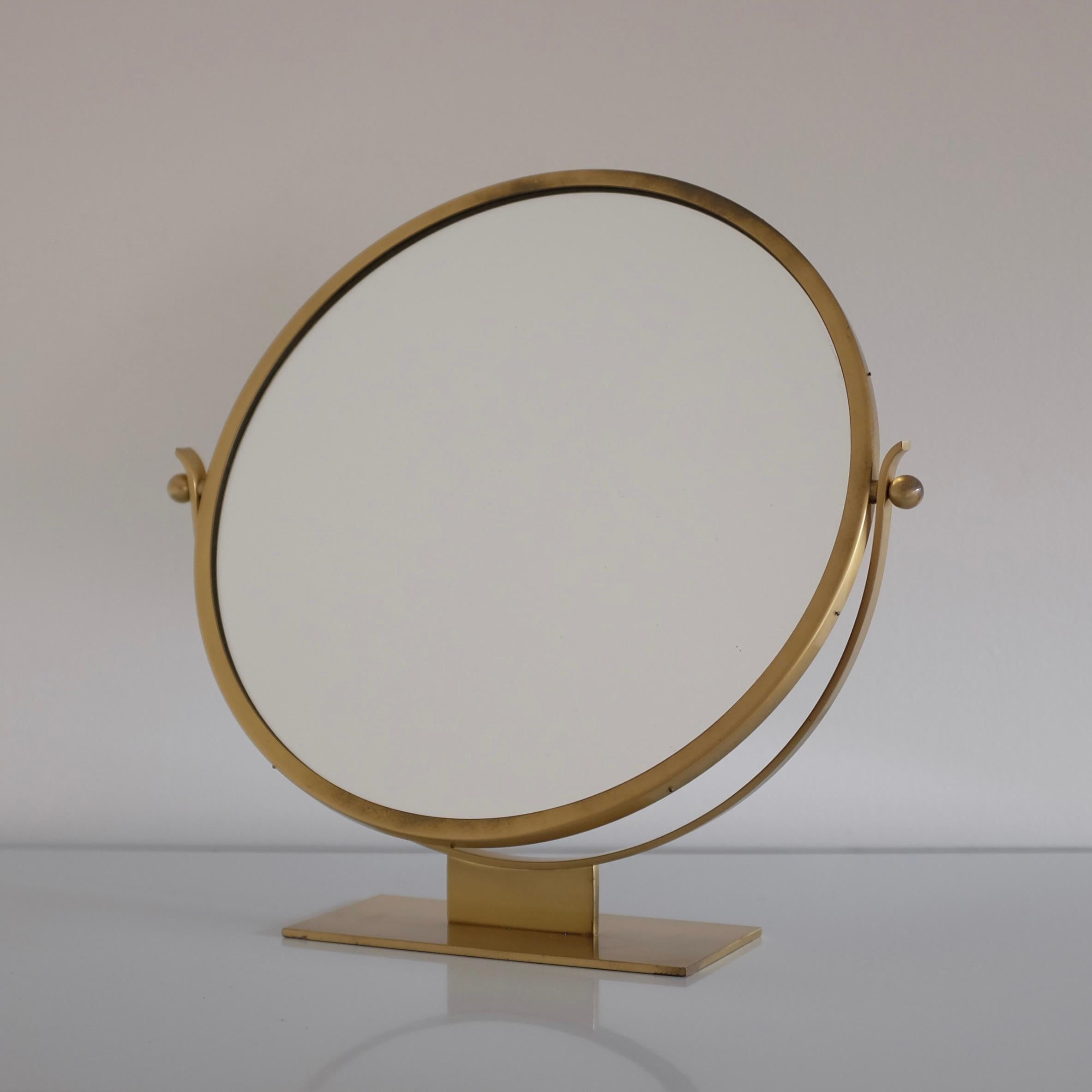 Magnifique miroir de table en laiton des années 1940/50 par Ystad-Metall, Suède. La base et le cadre en laiton avec un teck au dos du miroir sont très décoratifs dans leur conception simple et élégante. Usure due à l'âge avec quelques petites