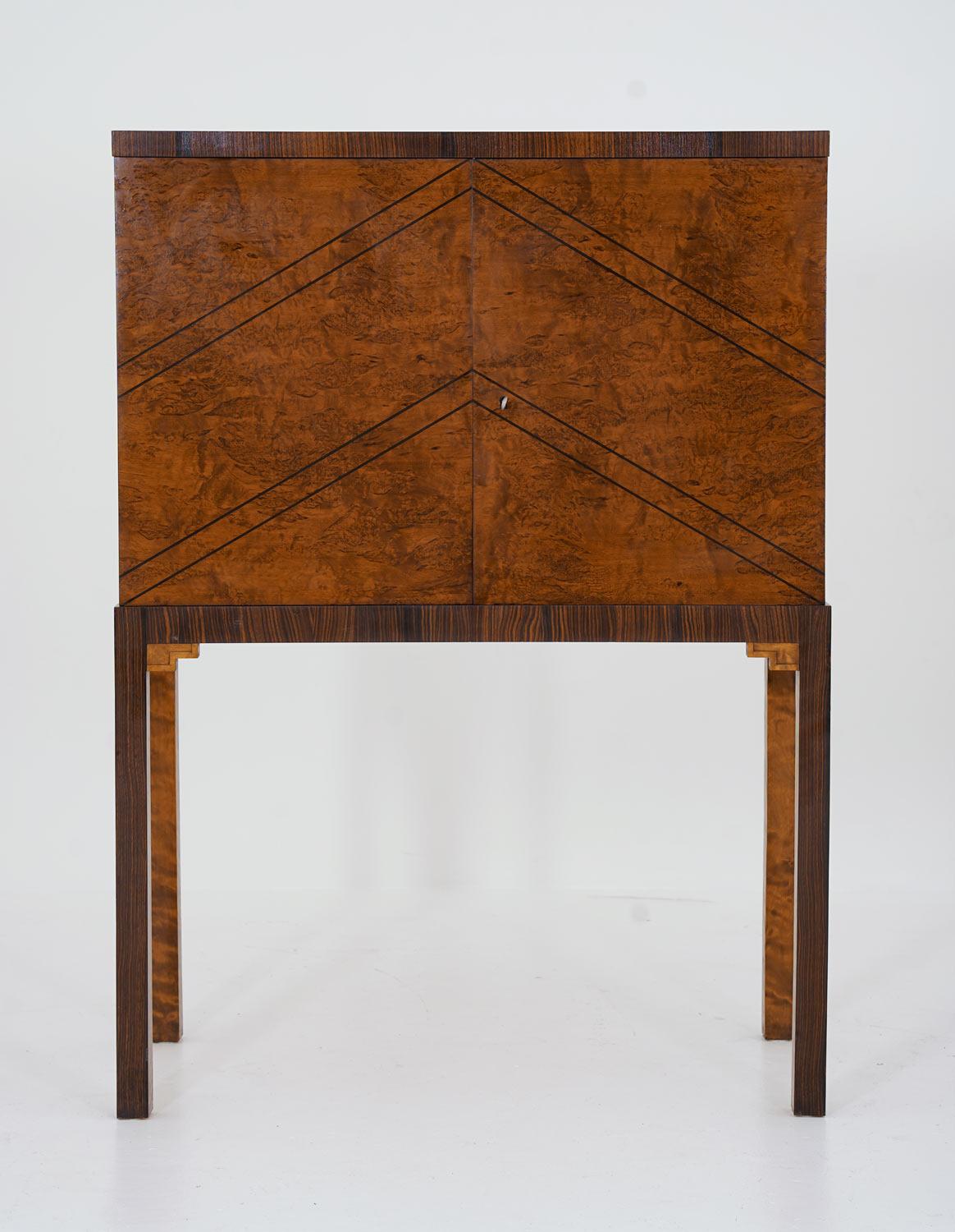 Stunning cabinet manufactured in Sweden, 1930s.
This cabinet is a great example of the golden age of Swedish furniture, showing superb quality in every detail. The front and sides are covered with elm-root veneer, with details in zebra wood. The