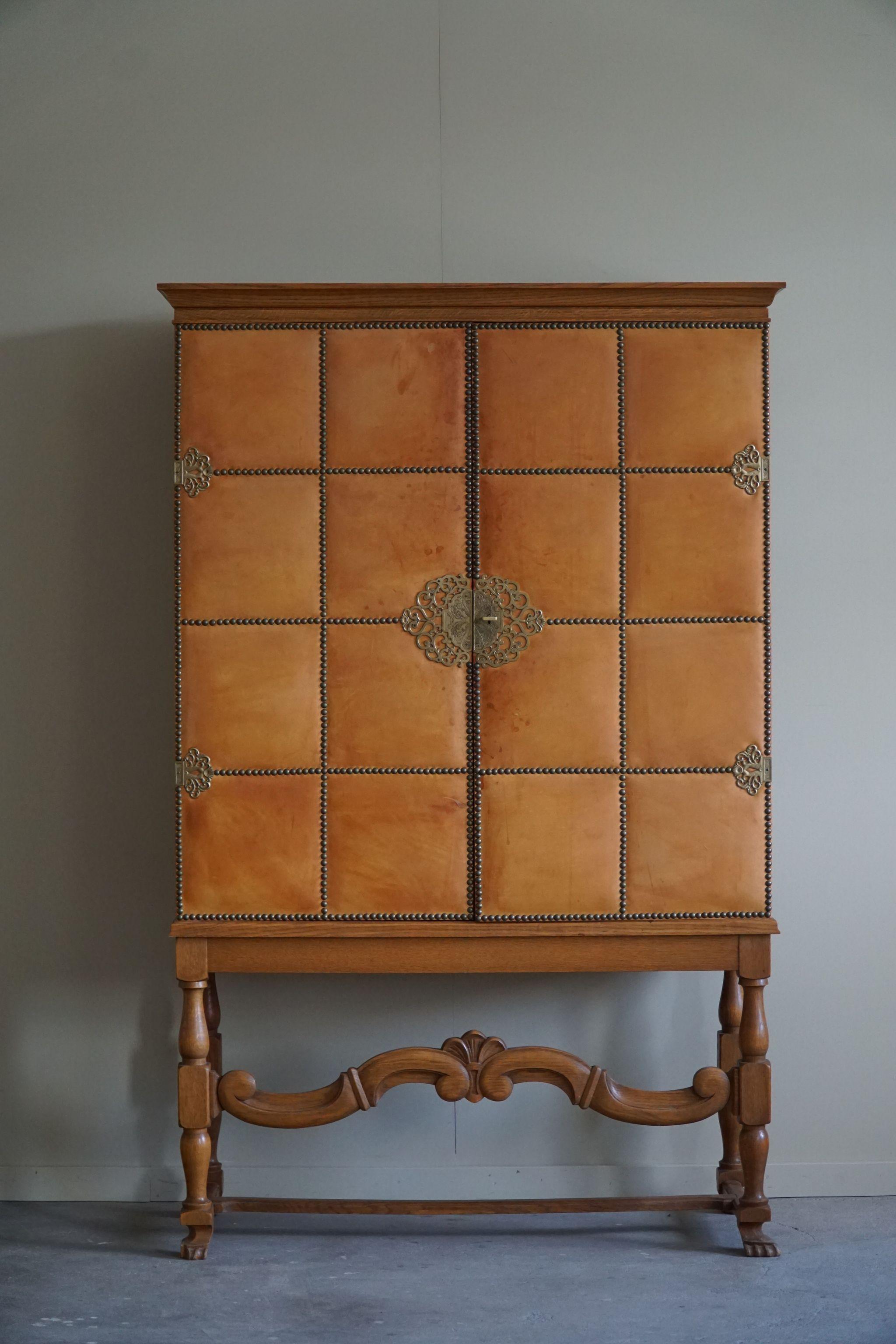 A spectacular cabinet attributed to the famous German born furniture designer Otto Schulz for Boet in Göteborg, Sweden.
The front is covered in a decadent cognac leather with brass nails and finely carved legs. Inside you will find two drawers and