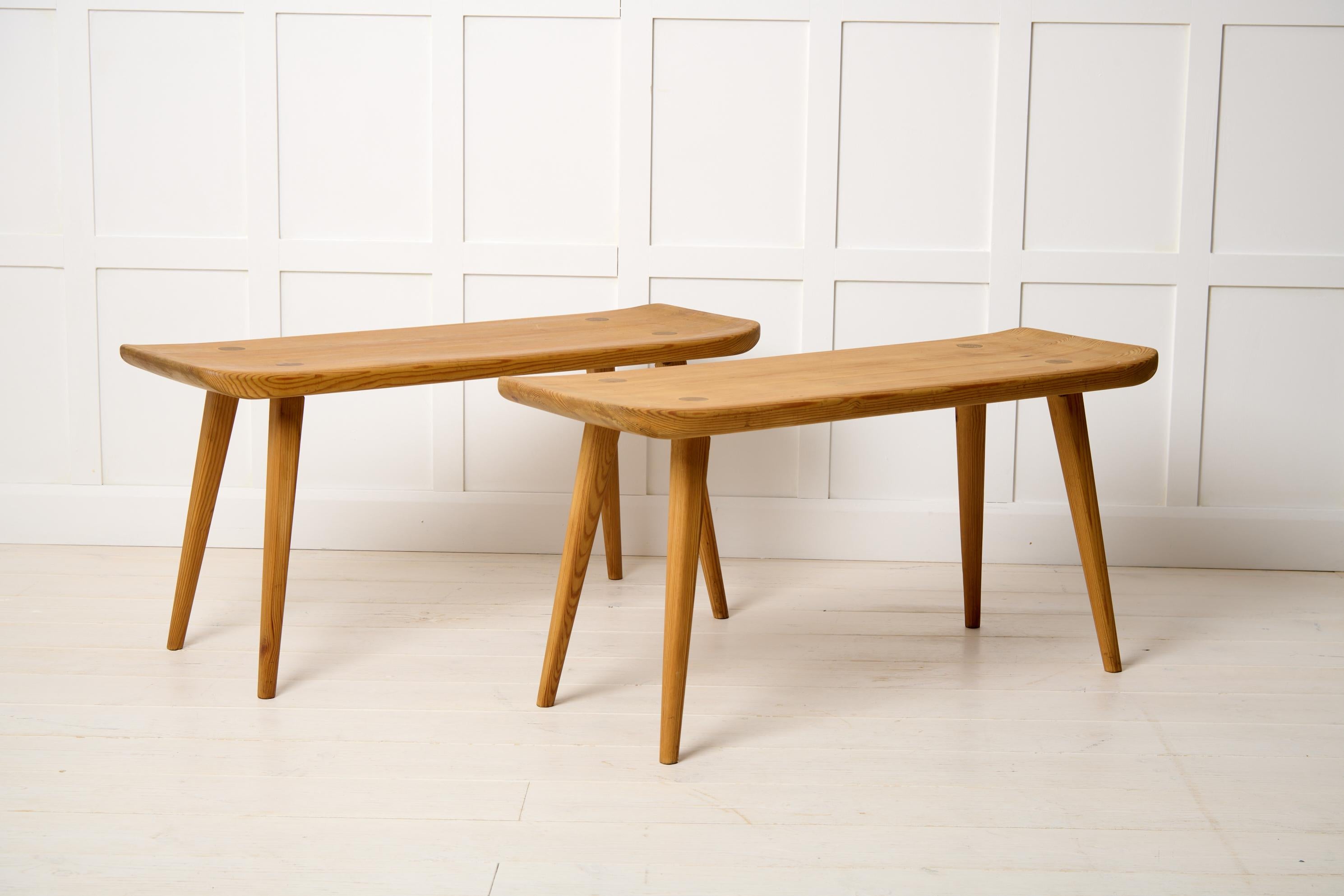 Swedish Modern benches Visingsö by Carl Malmsten. The two benches are from the mid 20th century and made in solid pine stained with acid. Designed in 1953 with beautifully curved characteristic edges. A markers mark underneath for “Svensk Fur”. Good