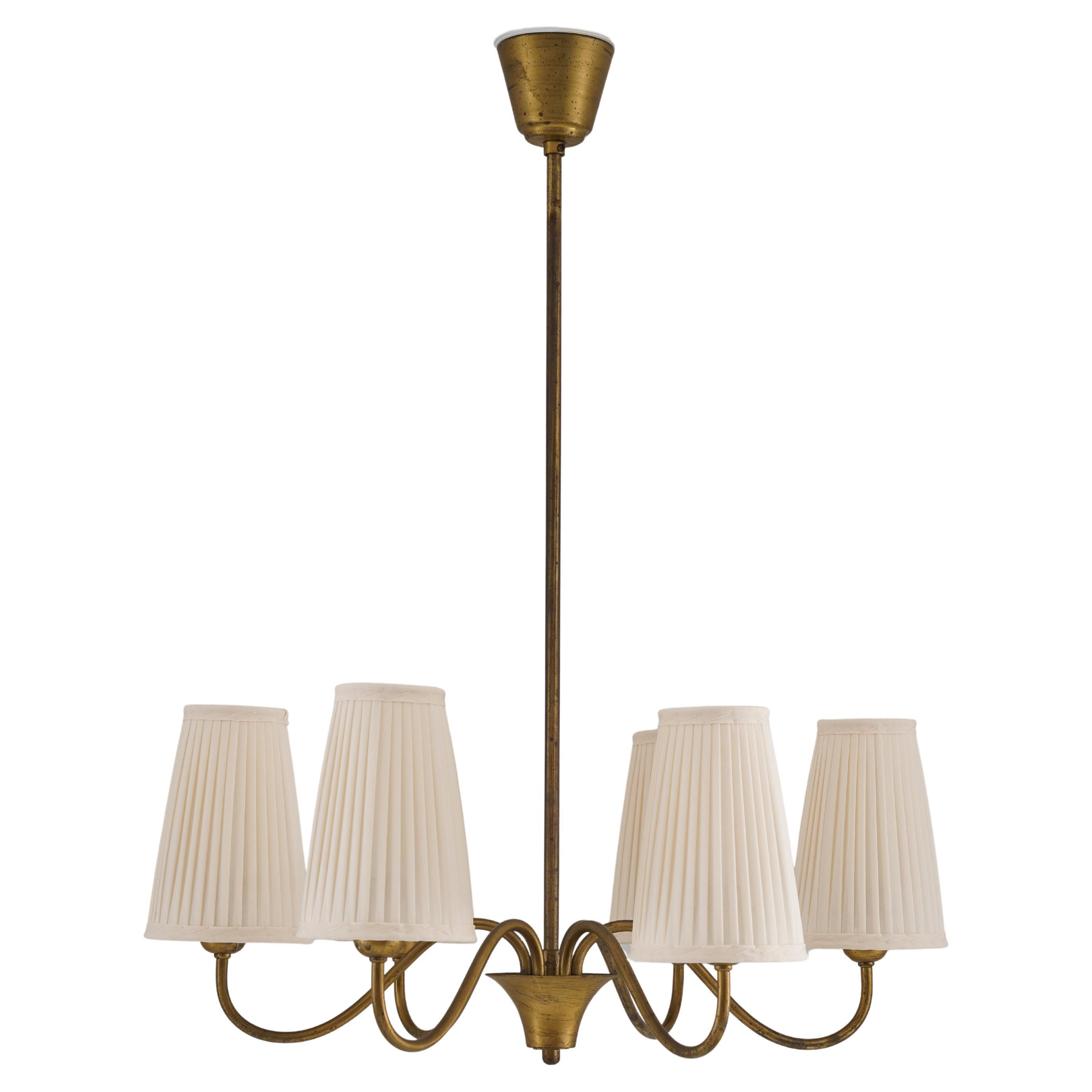 Un lampadario moderno svedese di Böhlmarks, realizzato in ottone negli anni Quaranta. Questo elegante apparecchio a sei bracci è caratterizzato da bracci graziosamente curvi che sostengono paralumi in seta plissettata, realizzati su misura con