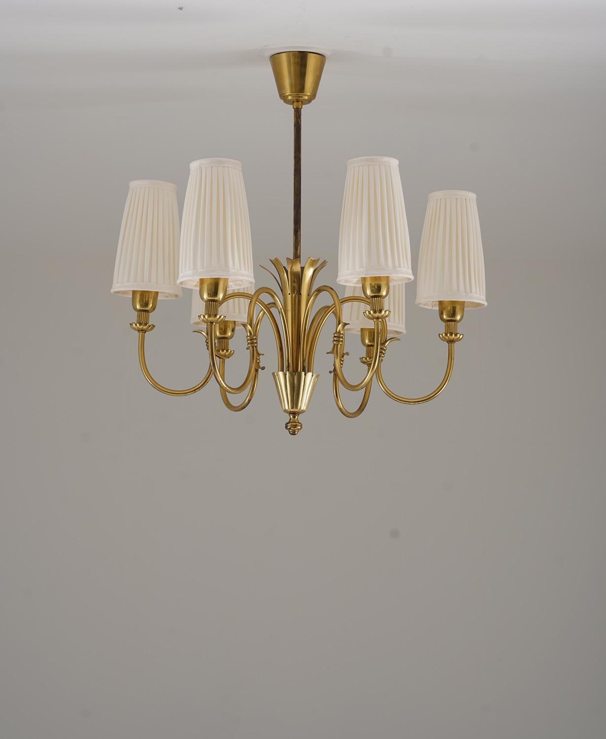 Elegante lampadario moderno svedese modello 11736 di Böhlmarks, Svezia.
Questo apparecchio offre 6 sorgenti luminose, nascoste da nuovi paralumi in tessuto plissettato a mano.

Condit: Ottime condizioni con un po' di patina sulle parti in ottone.