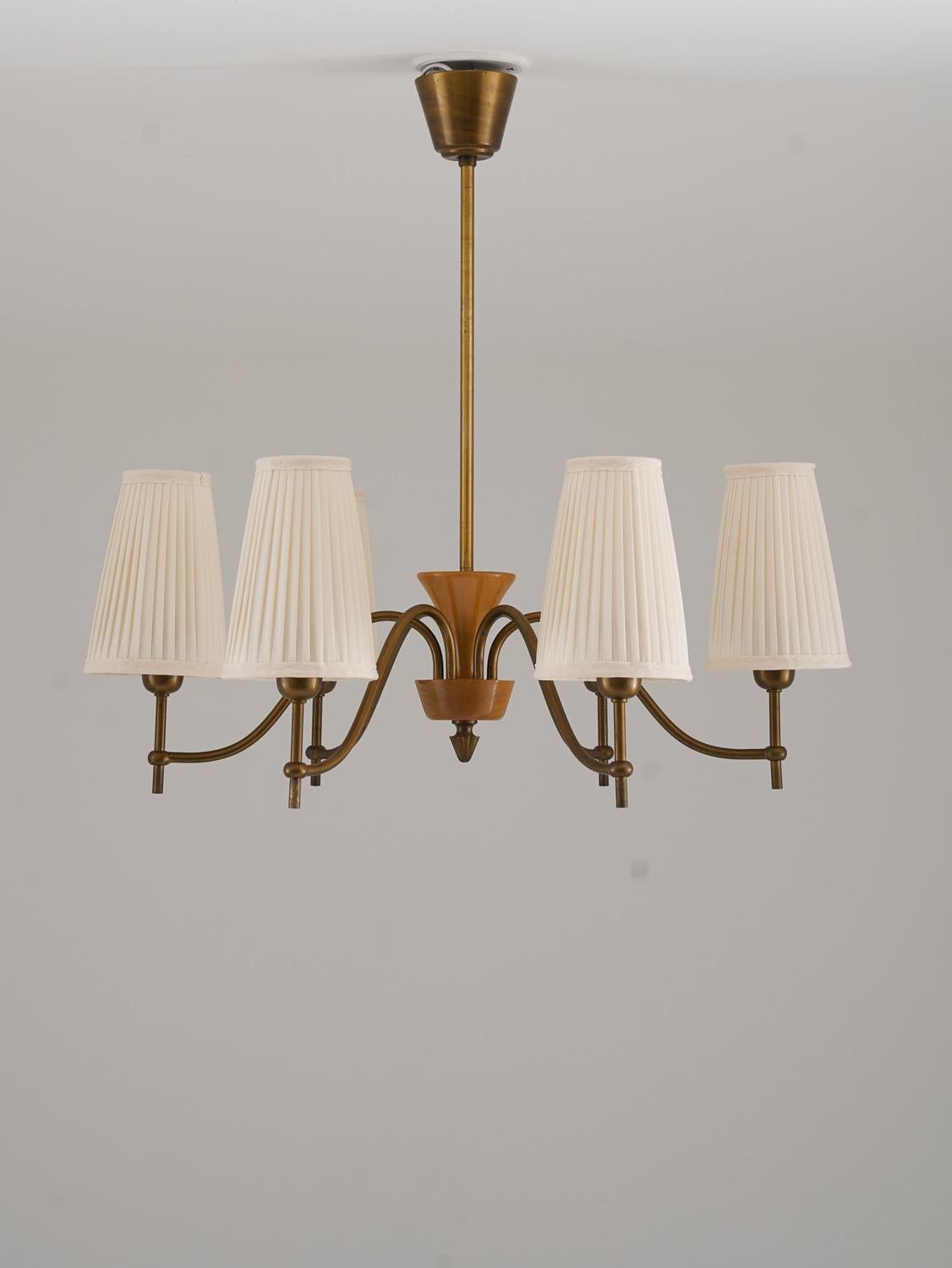 Lampadario moderno svedese di Böhlmarks, progettato e prodotto in Svezia negli anni '40. Il lampadario presenta una struttura in ottone graziosamente curvata con sei bracci elegantemente arcuati, ognuno dei quali contiene una sorgente luminosa. La
