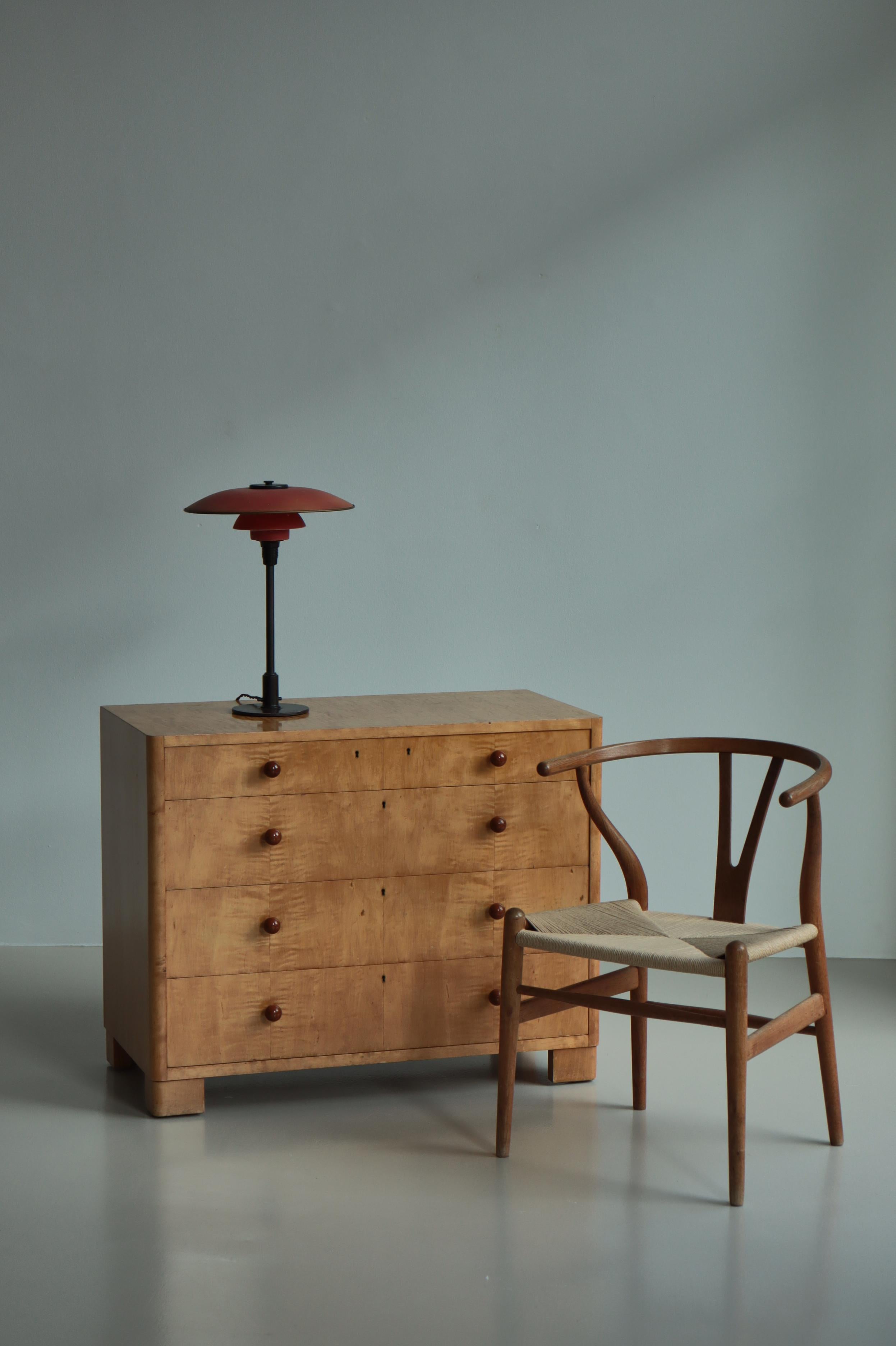 Wonderful little chest of drawers by Axel Larsson made in the 1930s at Svenska Möbekfabrikkerne, Bodafors, Sweden. Veneered in flamed birch with buds in hardwood. The 1000 series was designed in 1935, the same year that Axel Larsson became head of